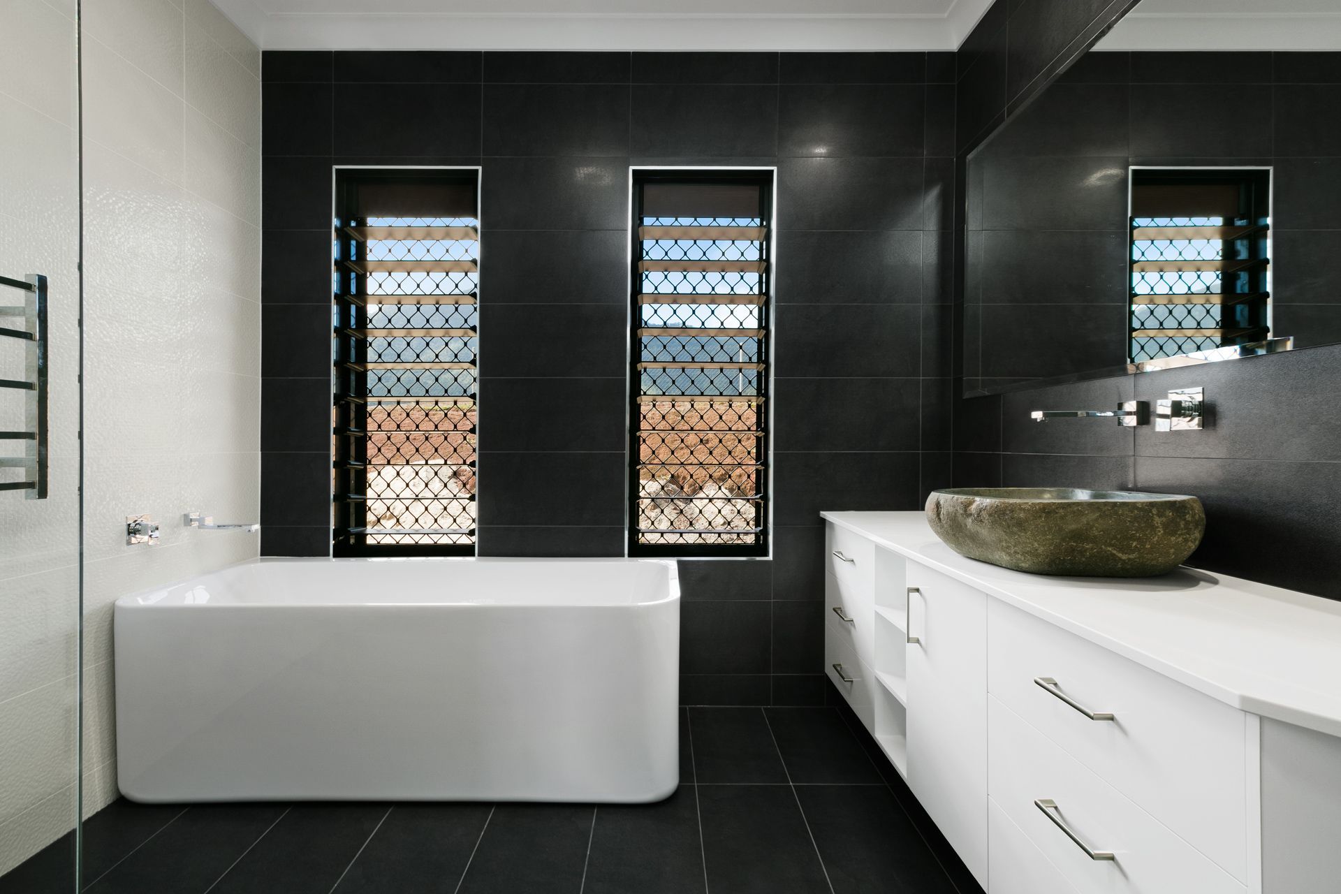 A Modern Bathroom With a White Freestanding Tub — Ashlee Jones Homes in Gordonvale, QLD