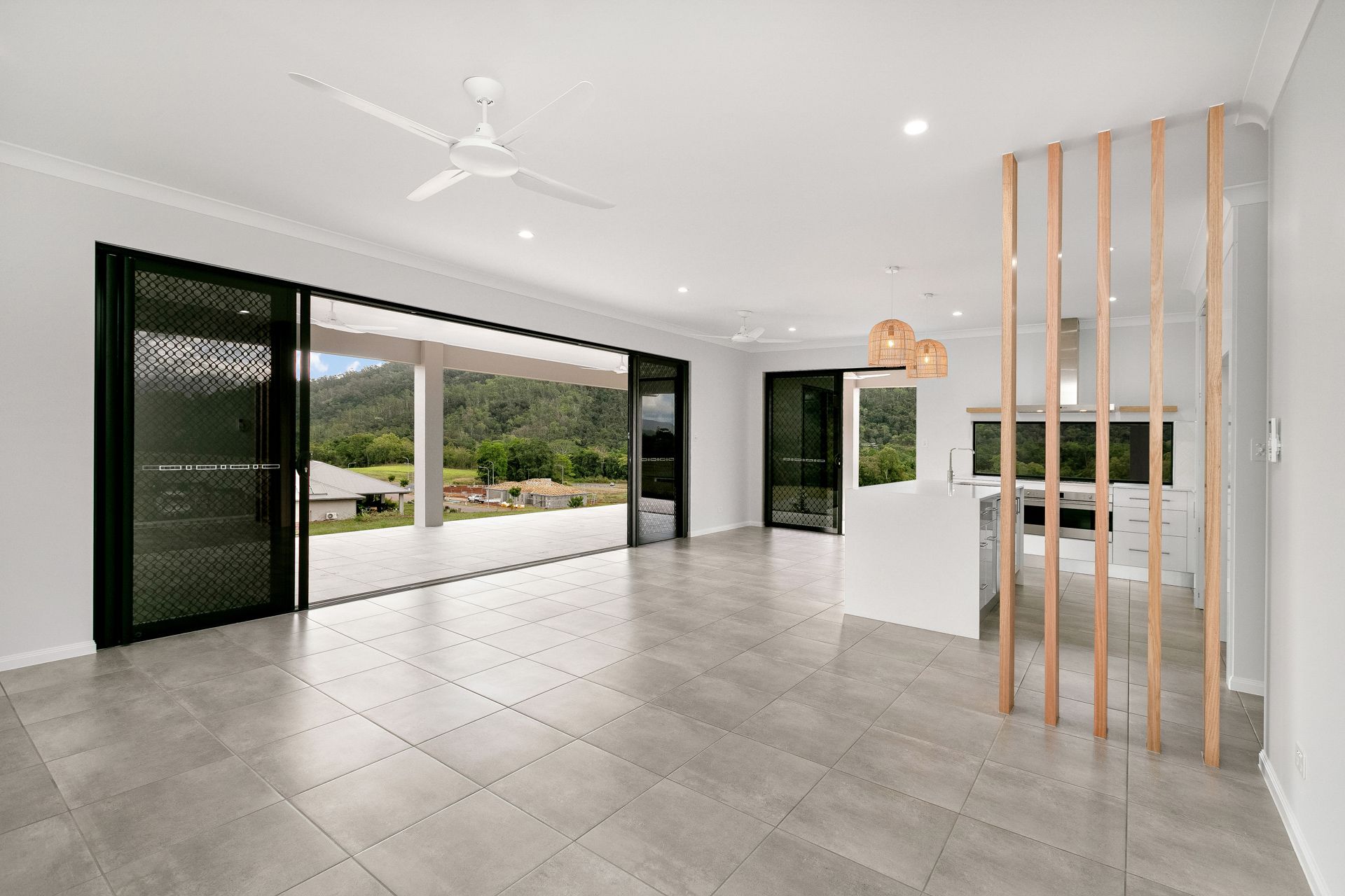 A Bright, Open-plan Living Area With Large Sliding Glass Doors — Ashlee Jones Homes in Gordonvale, QLD