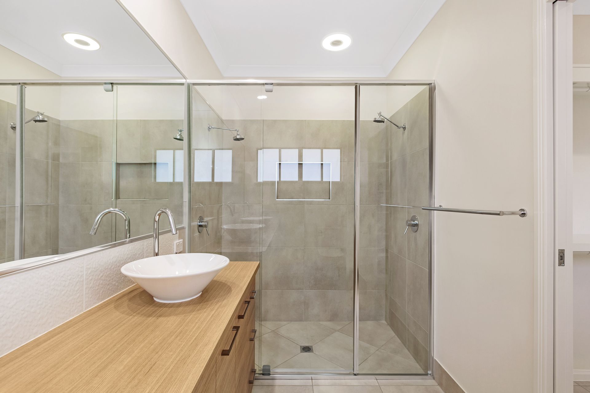 A Modern Bathroom With a Wooden Vanity — Ashlee Jones Homes in Gordonvale, QLD