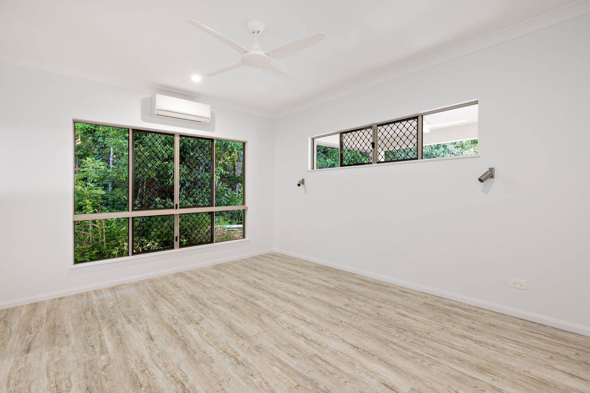 An Empty Room With White Walls, Light Wood Flooring — Ashlee Jones Homes in Gordonvale, QLD