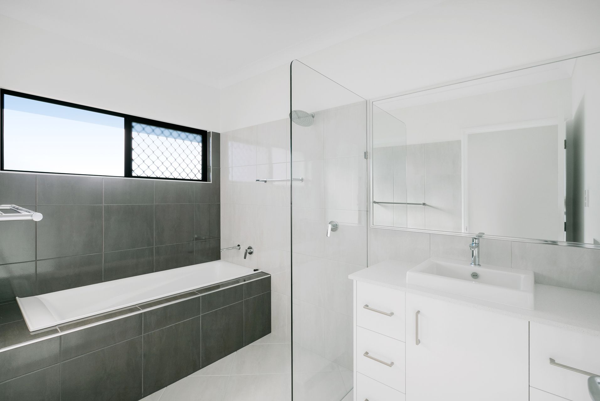 A Modern, Minimalist Bathroom With Gray Tiled Walls — Ashlee Jones Homes in Gordonvale, QLD