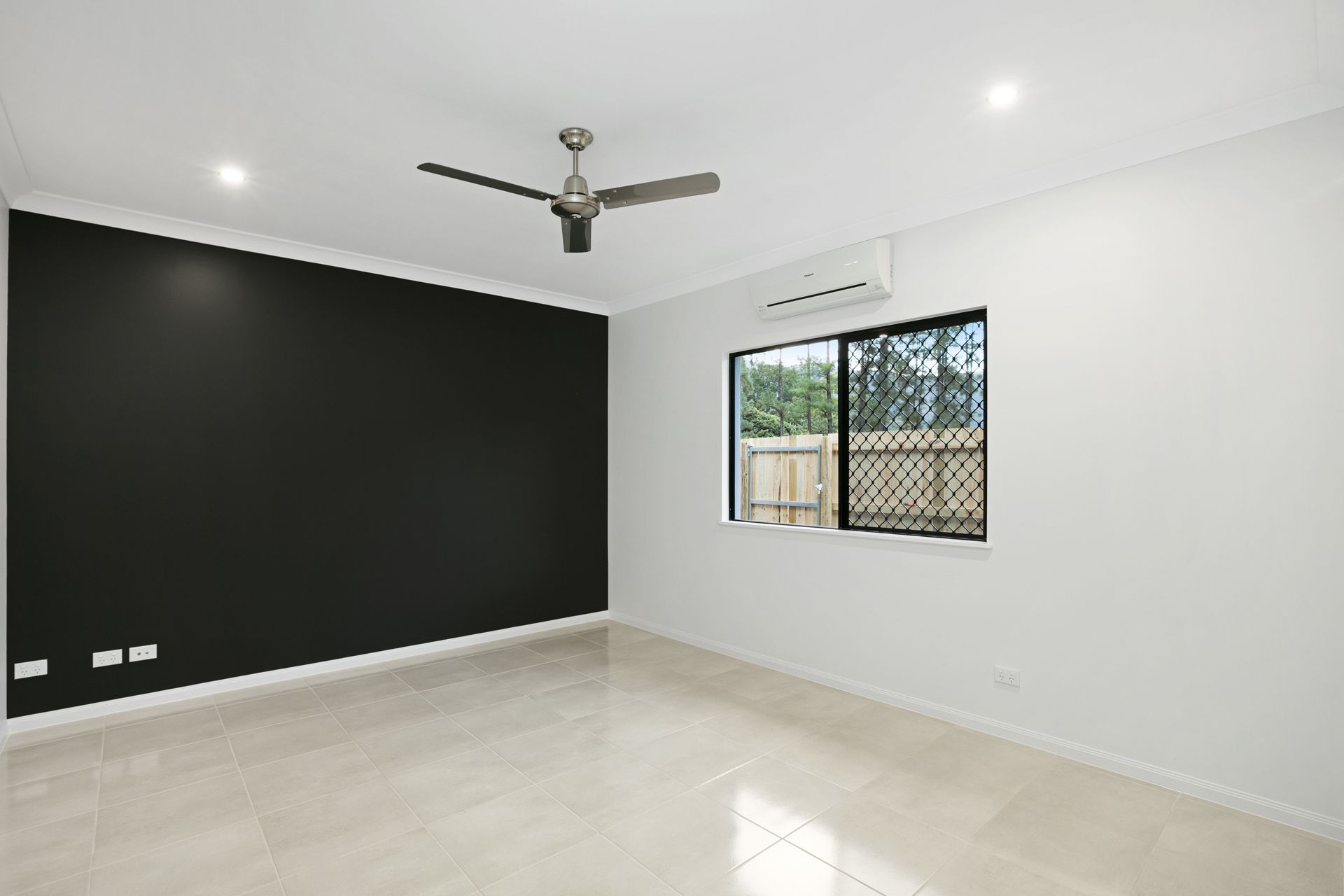 An Empty Bedroom With a Black Feature Wall — Ashlee Jones Homes in Gordonvale, QLD