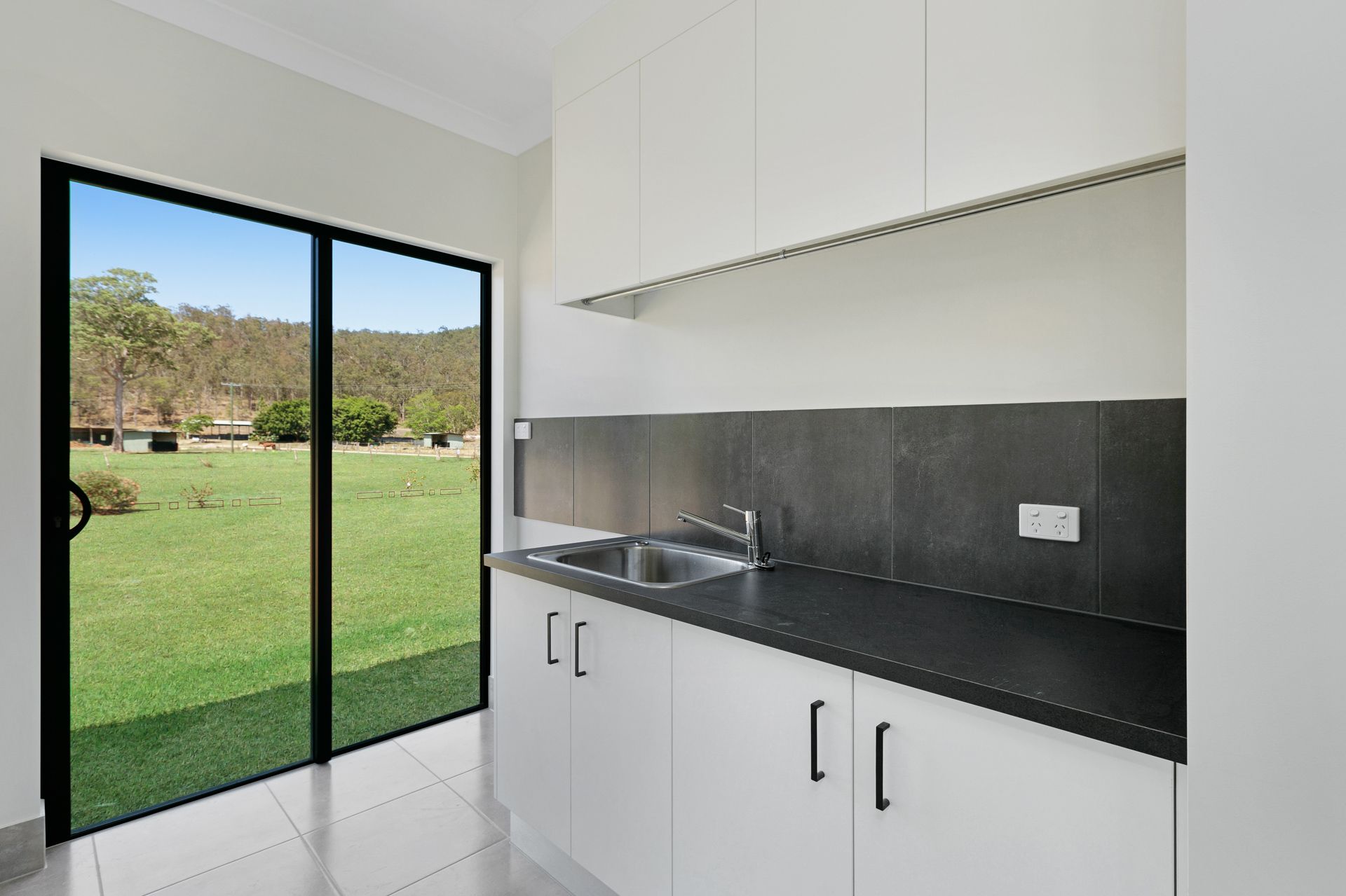 A Minimalist Kitchenette With White Cabinets — Ashlee Jones Homes in Gordonvale, QLD