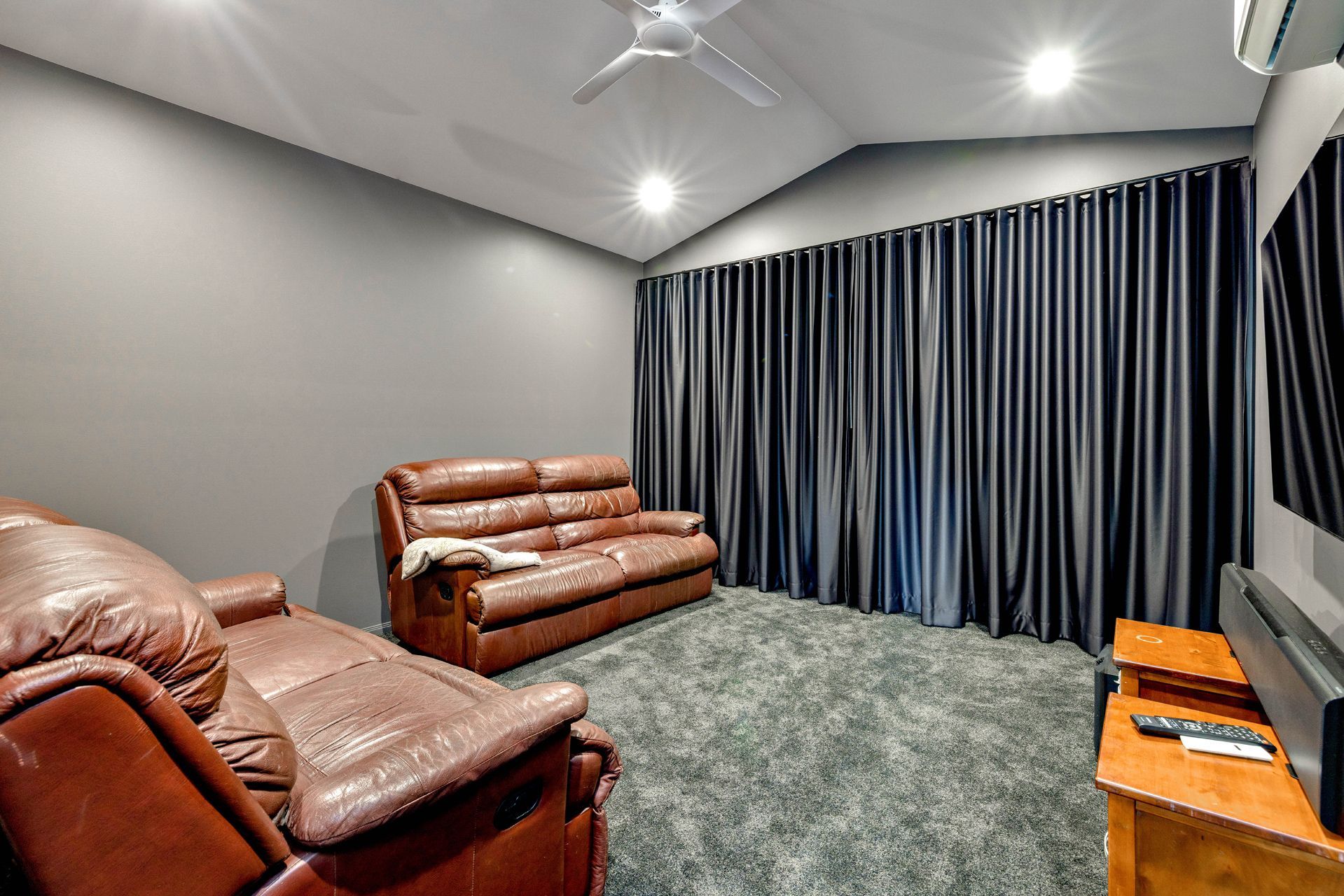 A Media Room Featuring Two Brown Leather Sofas — Ashlee Jones Homes in Gordonvale, QLD