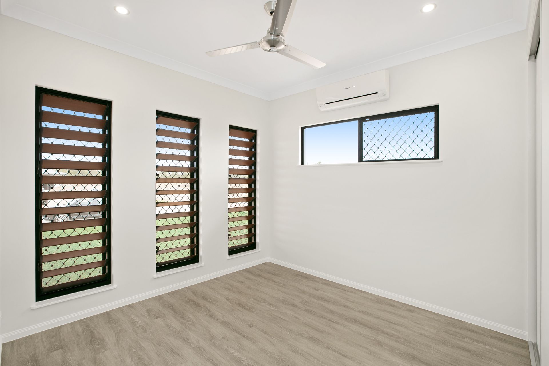 An Empty Room With White Walls, Light Wood Flooring — Ashlee Jones Homes in Gordonvale, QLD