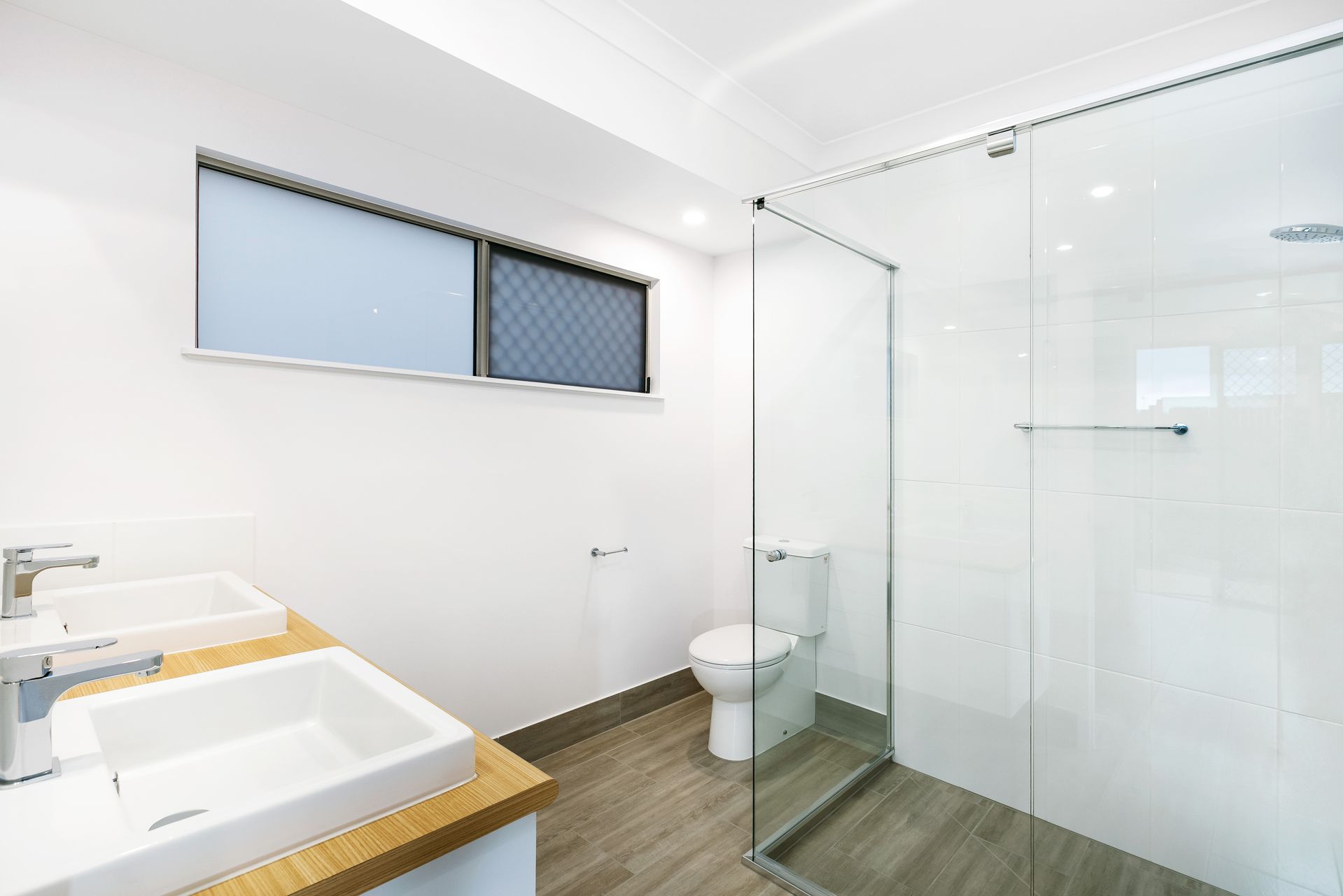 A Modern Bathroom With a Double Vanity, White Walls — Ashlee Jones Homes in Gordonvale, QLD