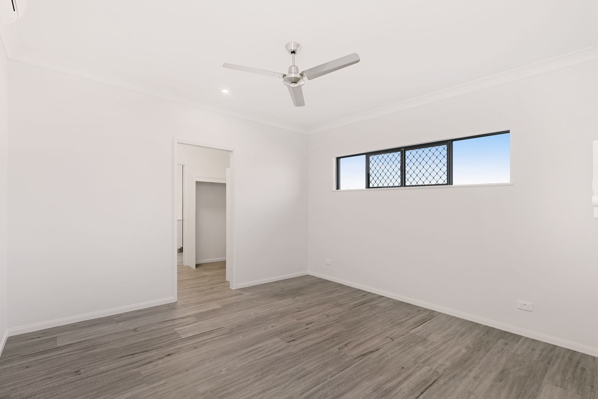 A Bright, Minimalist Room With White Walls, Wood-look Flooring — Ashlee Jones Homes in Gordonvale, QLD