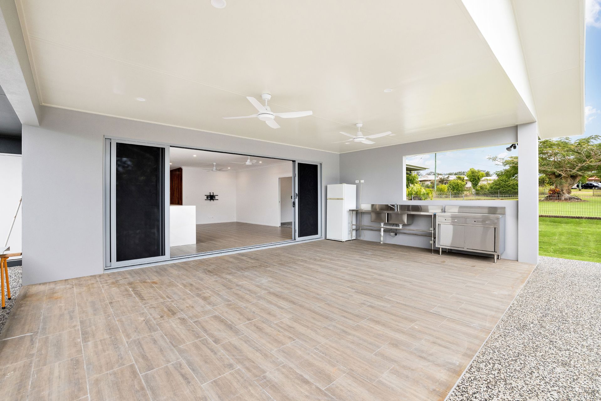 A Modern Outdoor Covered Patio With Wood-look Tile Flooring — Ashlee Jones Homes in Gordonvale, QLD