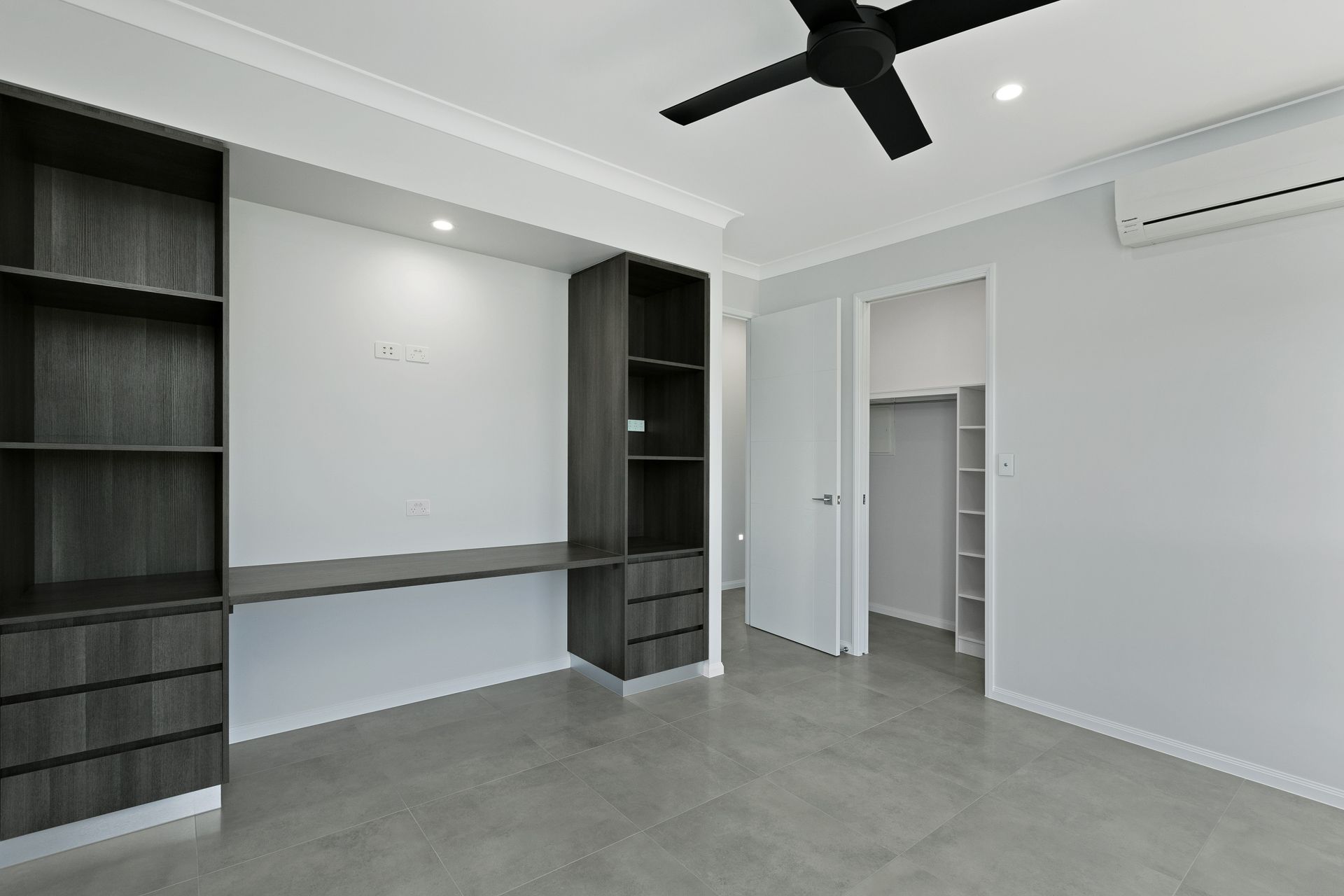 Modern Bedroom With Grey Tile Floor,  and a Black Ceiling Fan — Ashlee Jones Homes in Gordonvale, QLD