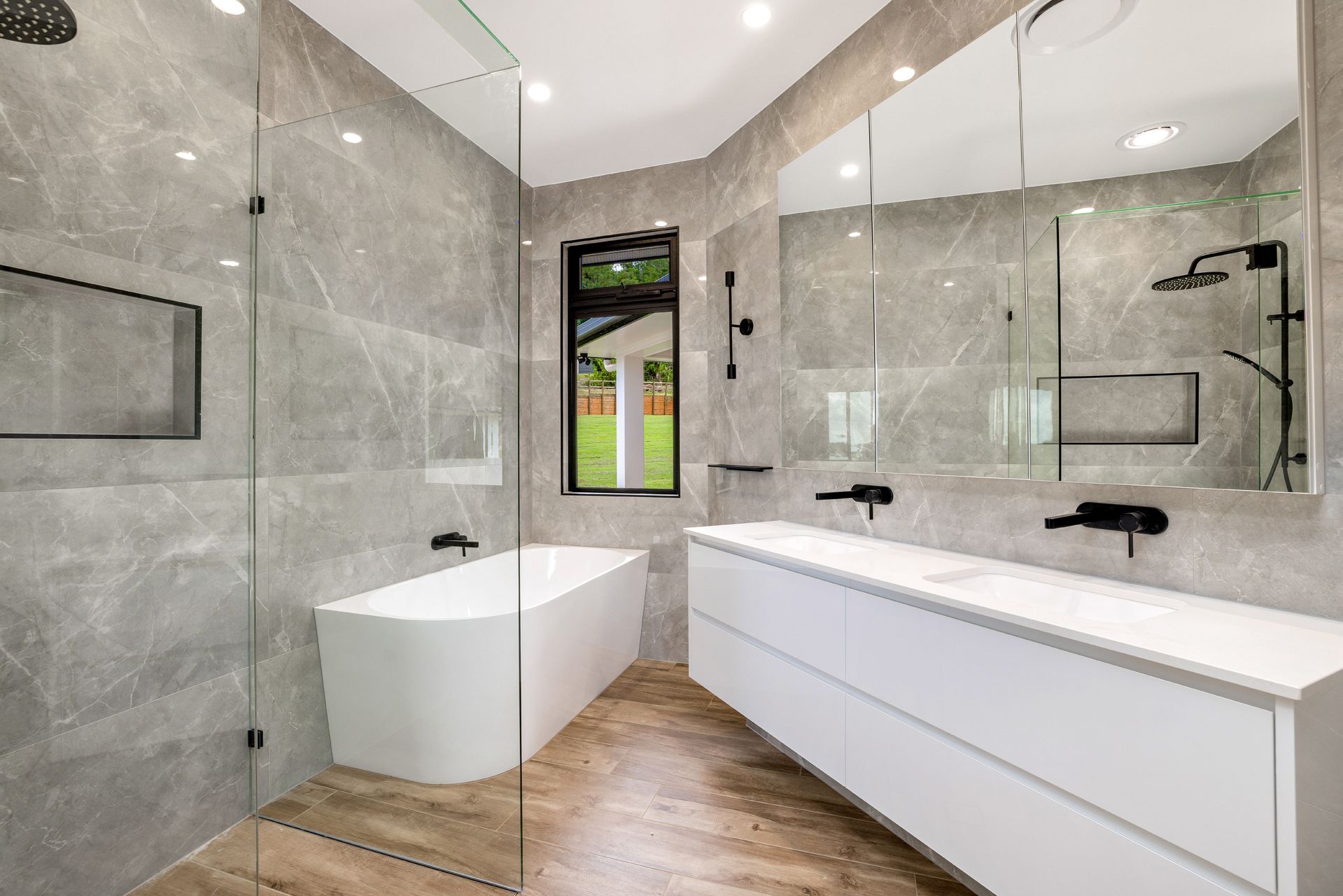 A Modern Bathroom Featuring Gray Marble-tiled Walls, a Double Vanity — Ashlee Jones Homes in Gordonvale, QLD