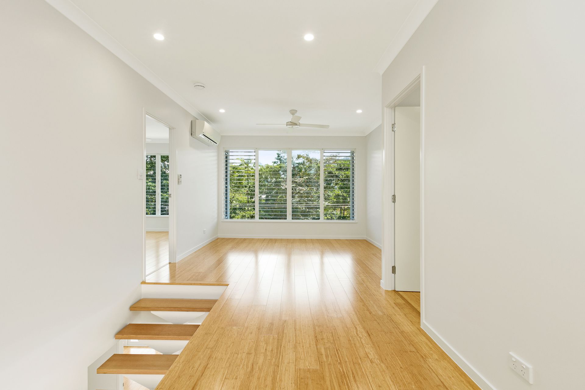 A Bright Room With Light Wood Floors, Leading to a Sunken Area — Ashlee Jones Homes in Gordonvale, QLD