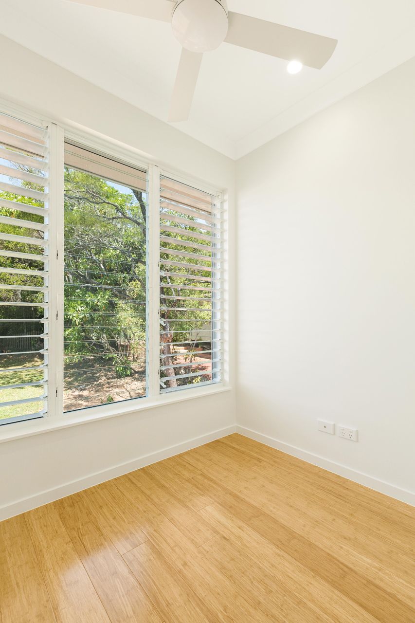 Empty Room With Light Wood Floors, White Walls, Large Shuttered Windows — Ashlee Jones Homes in Gordonvale, QLD