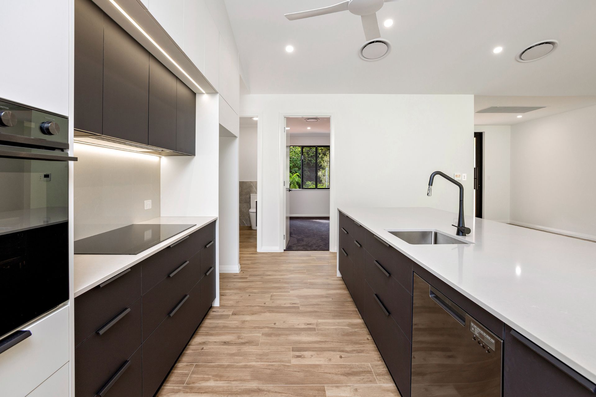 Modern Kitchen With Dark Wood Cabinetry — Ashlee Jones Homes in Gordonvale, QLD