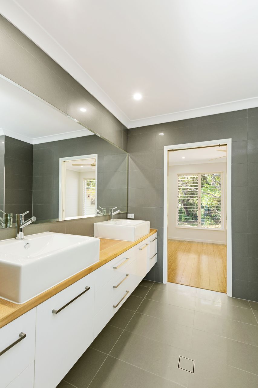 A Modern Bathroom With White Vessel Sinks — Ashlee Jones Homes in Gordonvale, QLD