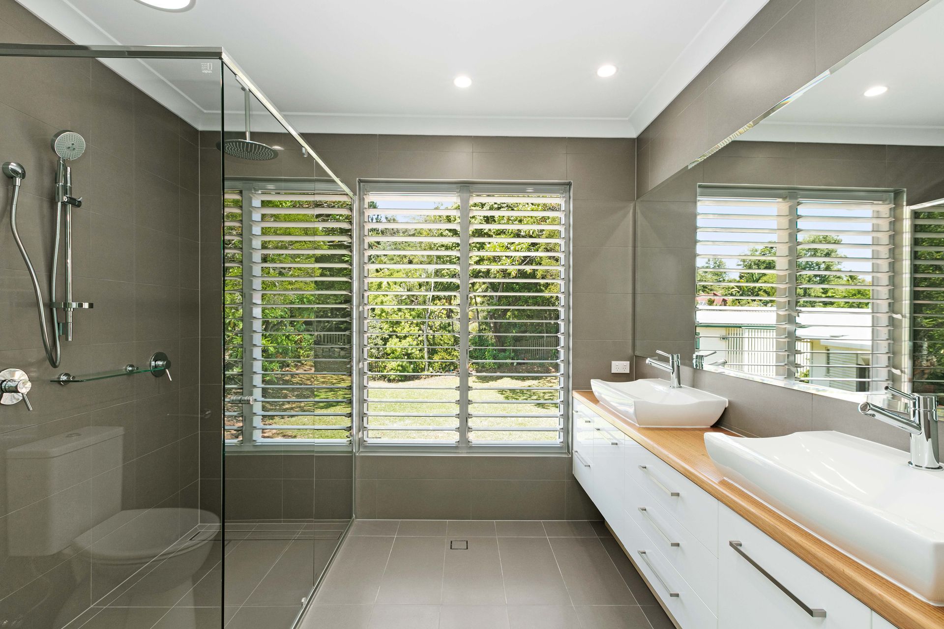 Modern, Neutral-toned Bathroom With a Large Glass Shower — Ashlee Jones Homes in Gordonvale, QLD