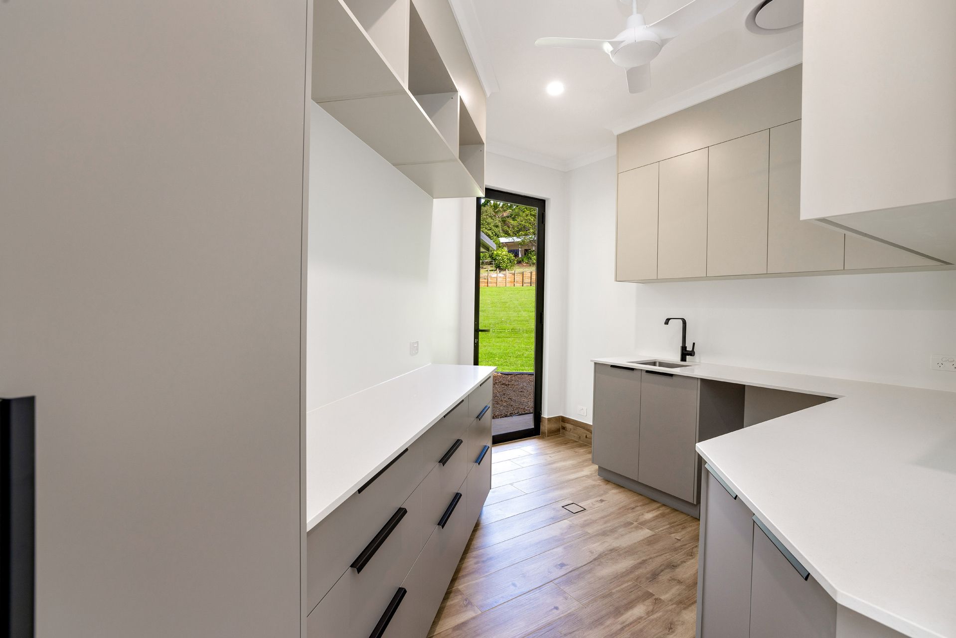 A Modern Laundry Room With Taupe Cabinets — Ashlee Jones Homes in Gordonvale, QLD