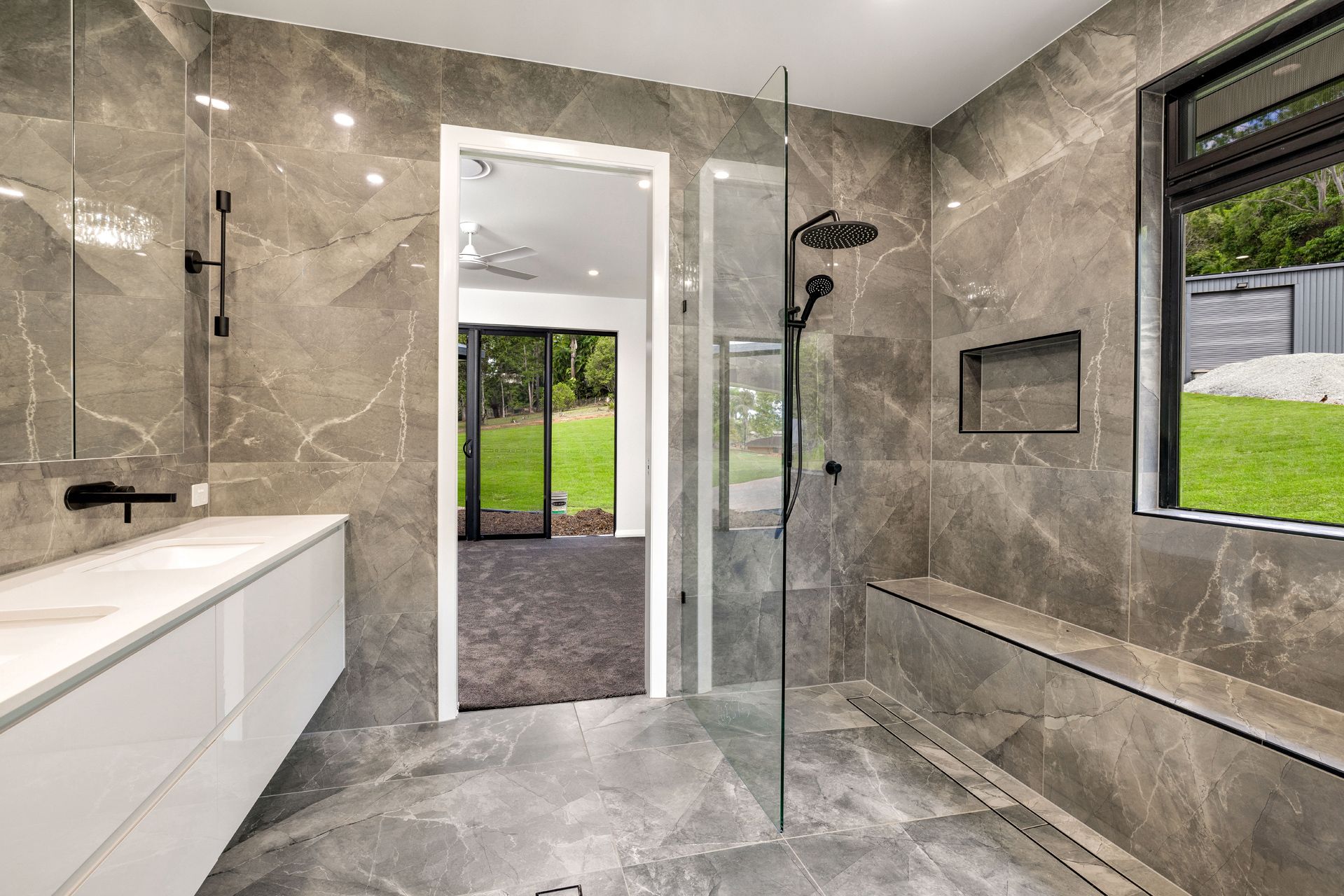 A Modern Bathroom With Grey Marble-tiled Walls — Ashlee Jones Homes in Gordonvale, QLD
