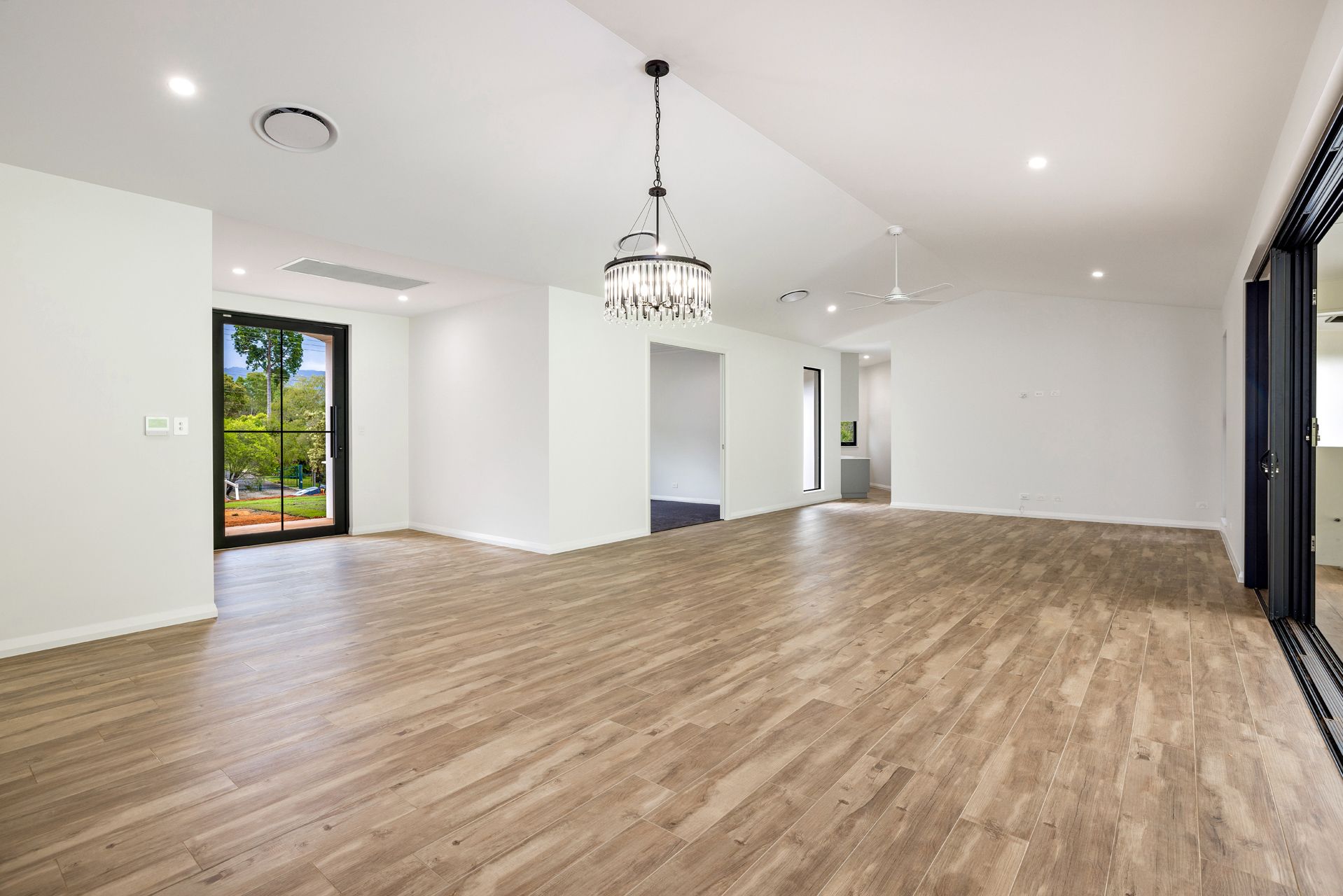 An Open-plan Interior Space With Wood-look Flooring — Ashlee Jones Homes in Gordonvale, QLD