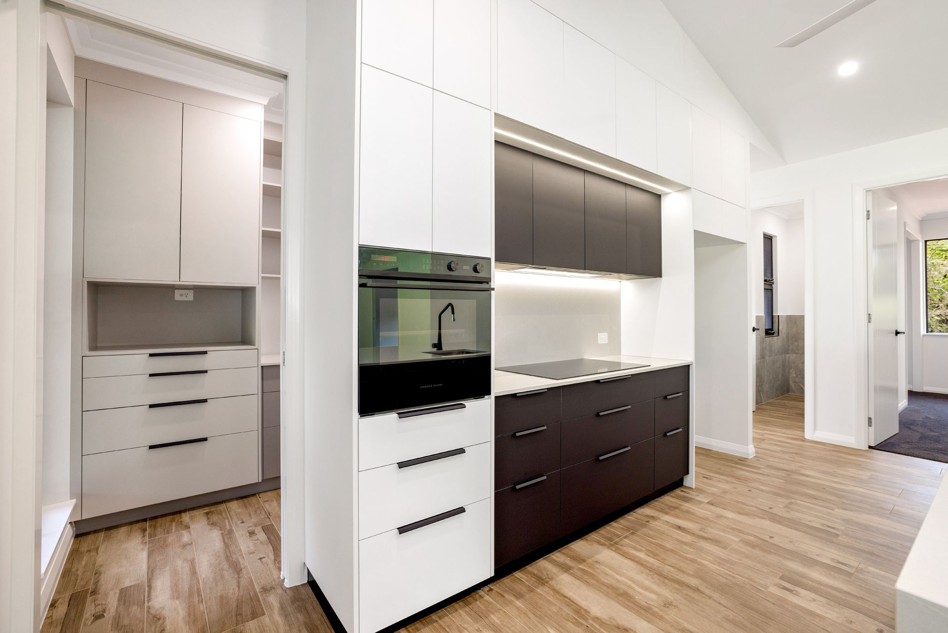 Modern Kitchen With White and Dark Brown Cabinetry — Ashlee Jones Homes in Gordonvale, QLD