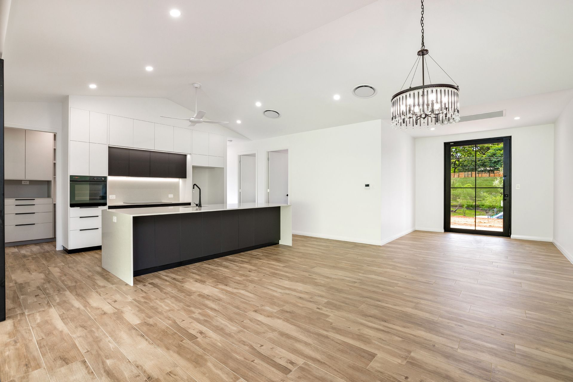 Modern Kitchen Featuring White Walls, Wood-look Flooring — Ashlee Jones Homes in Gordonvale, QLD