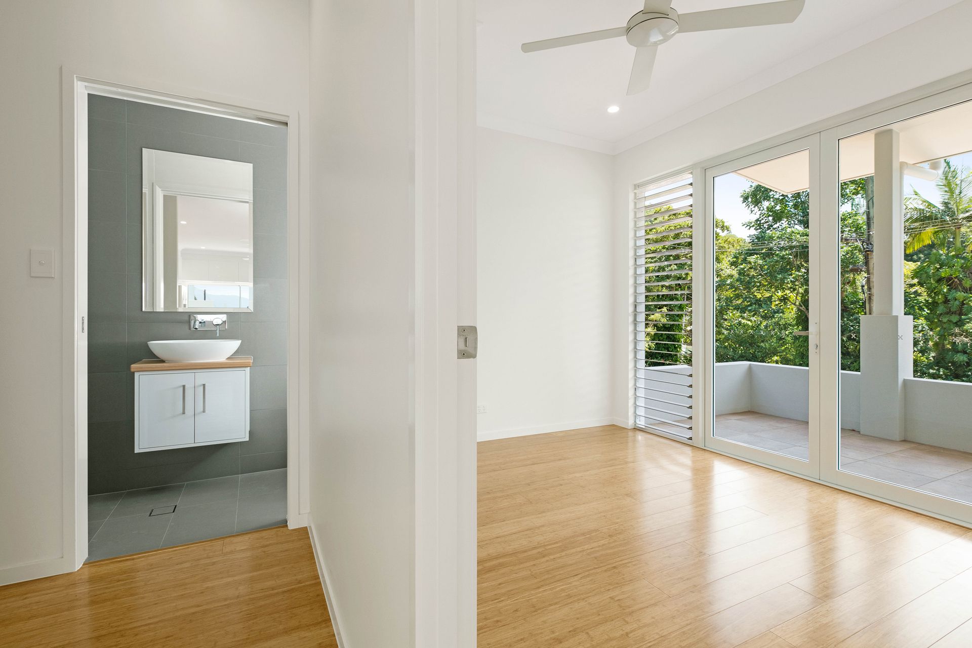 A Bedroom With Light Wood Flooring, a Ceiling Fan — Ashlee Jones Homes in Gordonvale, QLD