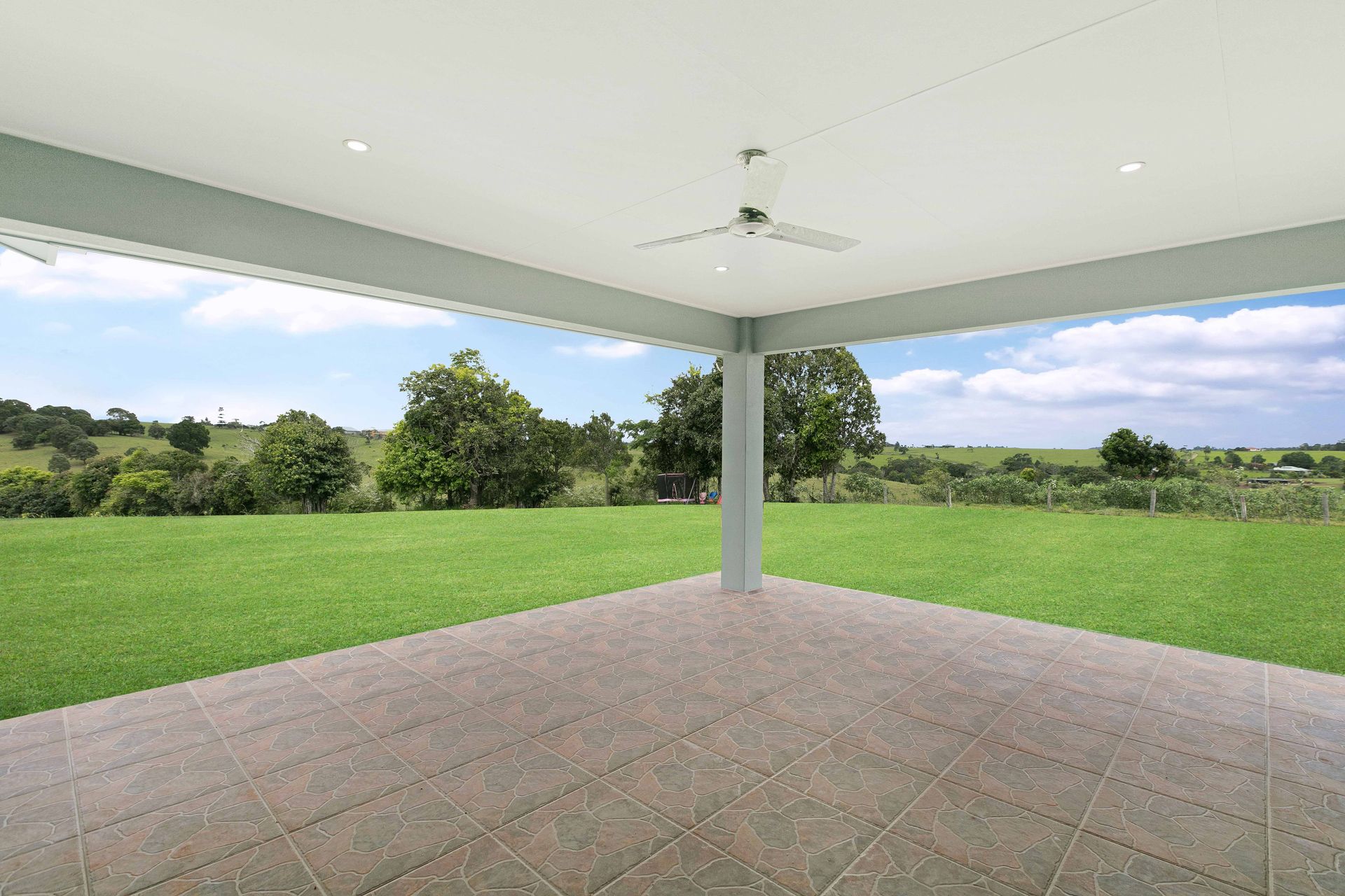 A Spacious, Covered Outdoor Patio With a Ceiling Fan — Ashlee Jones Homes in Gordonvale, QLD