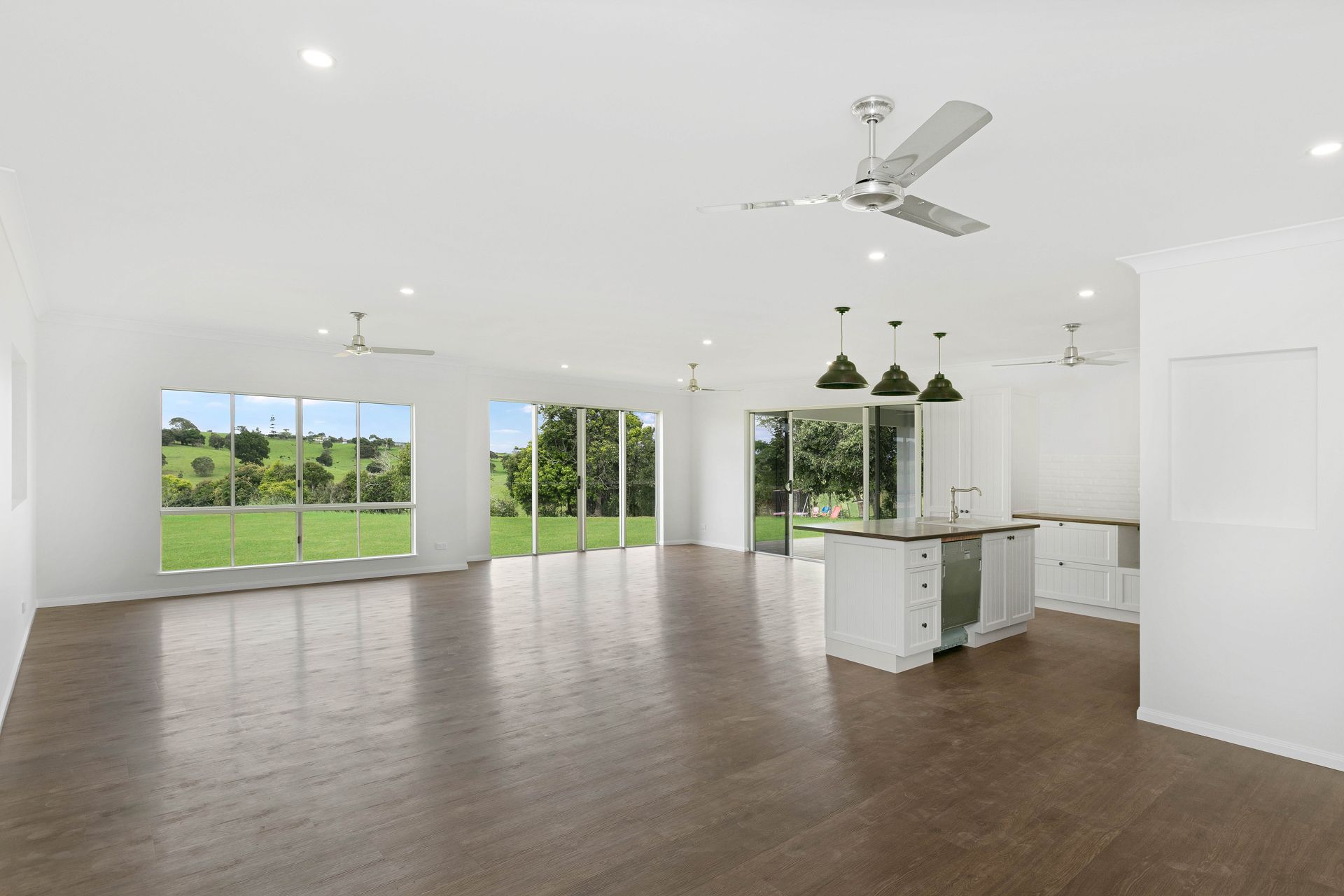 An Open-concept Living Area With Dark Wood Floors — Ashlee Jones Homes in Gordonvale, QLD