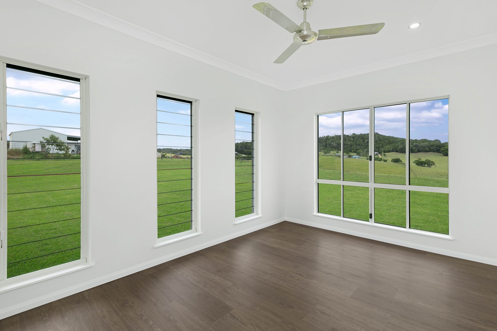 An Empty Room With White Walls, Dark Wood Floors — Ashlee Jones Homes in Gordonvale, QLD