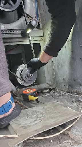 A man wearing black gloves is working on a machine.