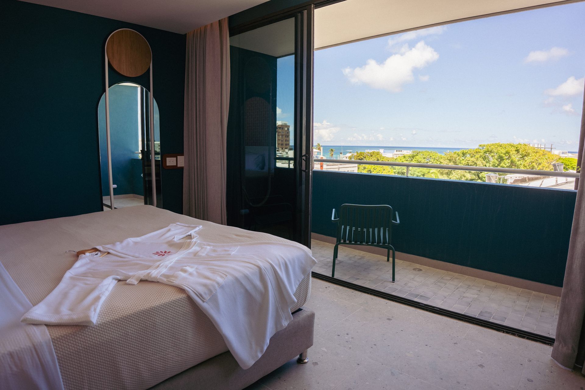 Quartos nas ilhas de San Andrés com cama king, parede azul, grande janela panorâmica e vista da paisagem a partir da varanda
