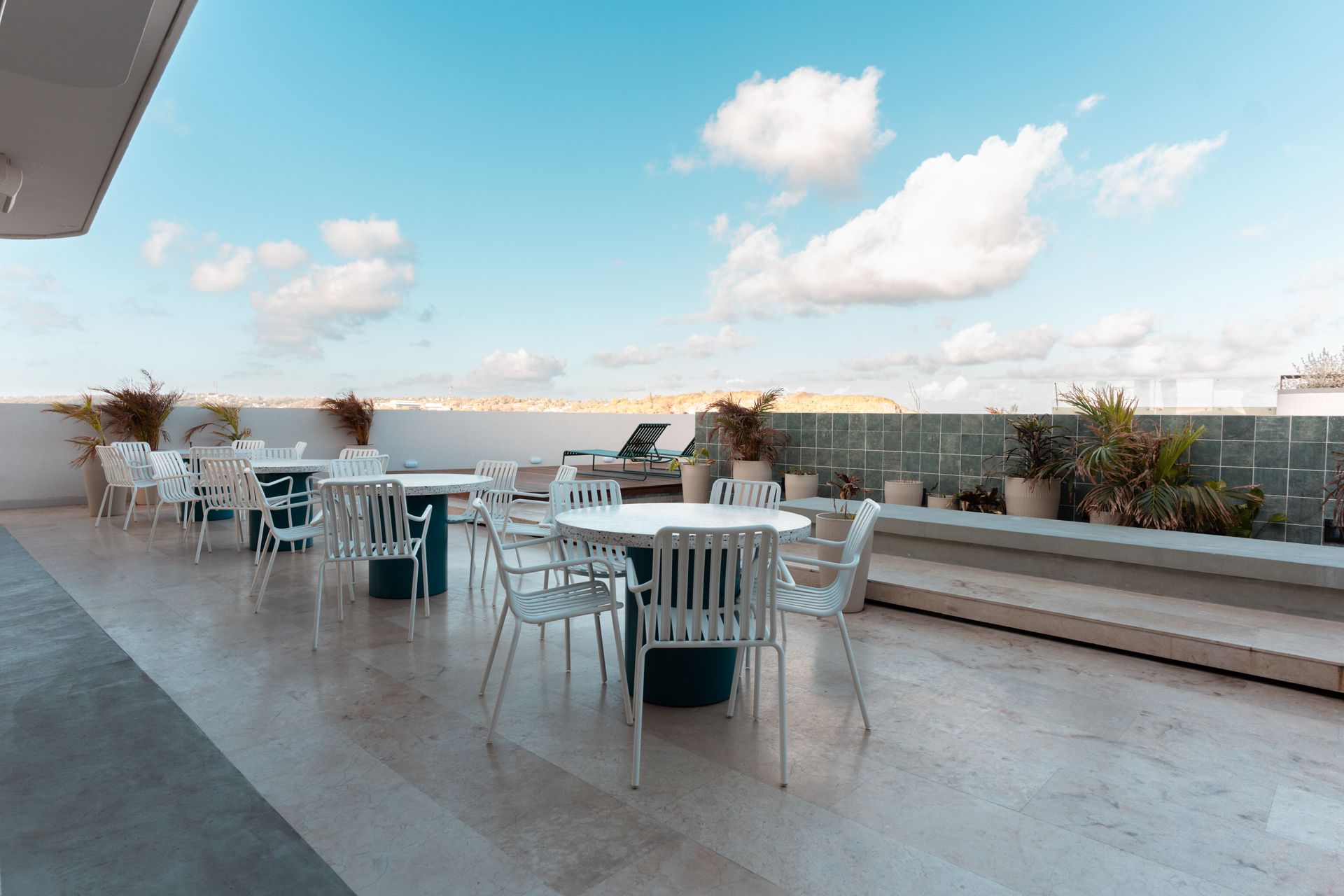 Rooftop living room with tables, chairs, and ocean views in a hotel in san andres