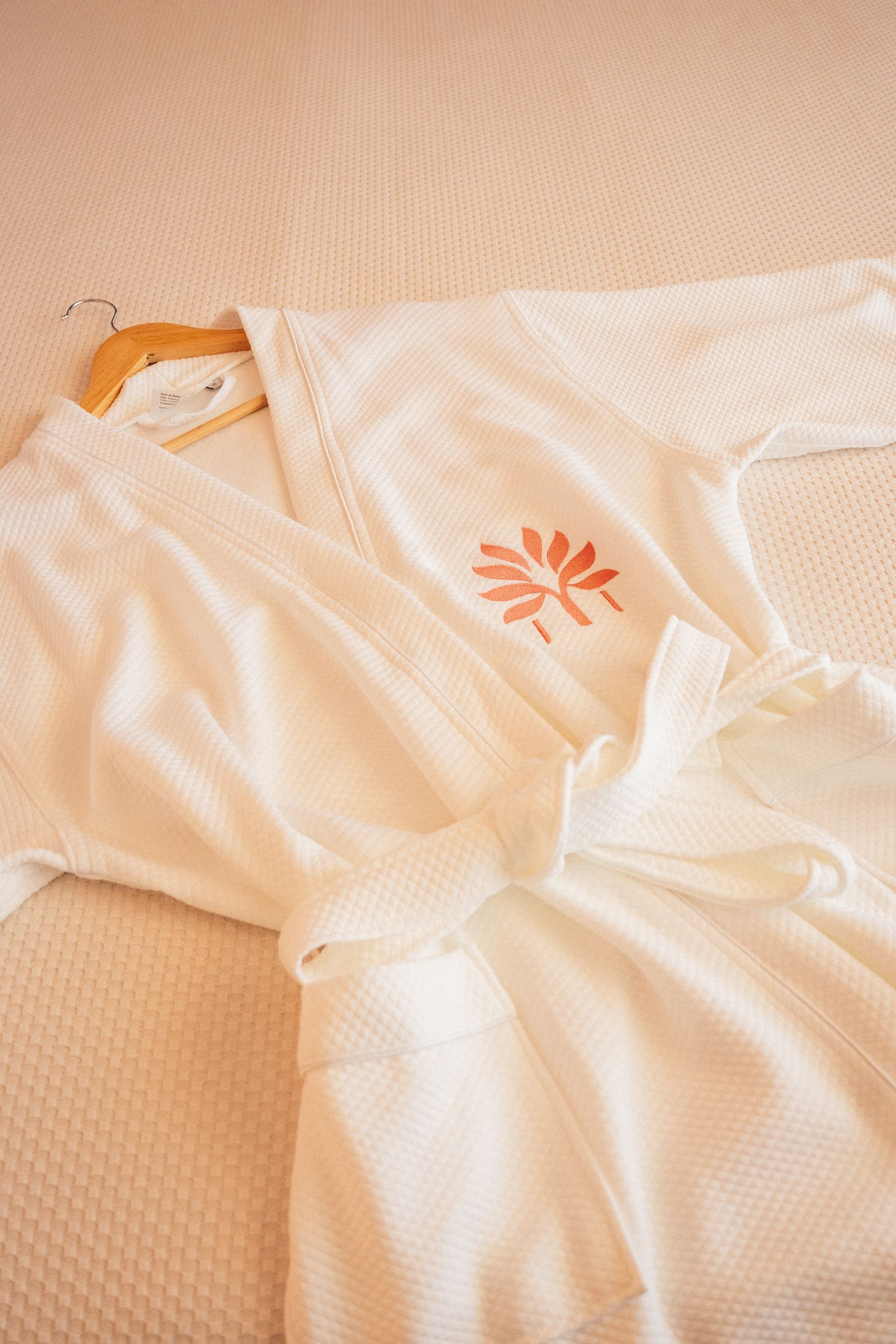 White robe on the bed with coral embroidery from the Zapadilly Hotel shop in San Andrés