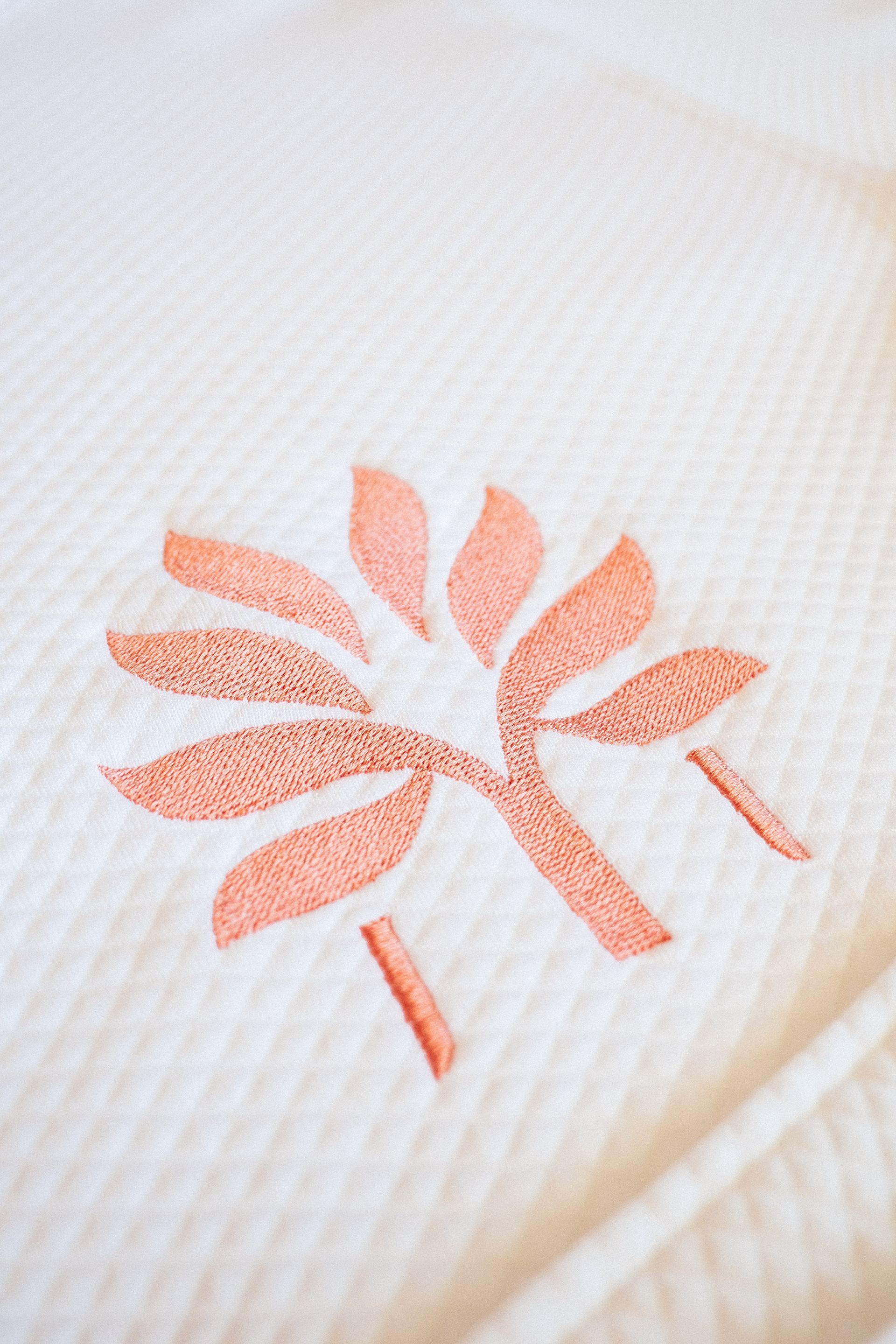 Detail of a white robe with coral embroidery in the Zapadilly Hotel shop in San Andres
