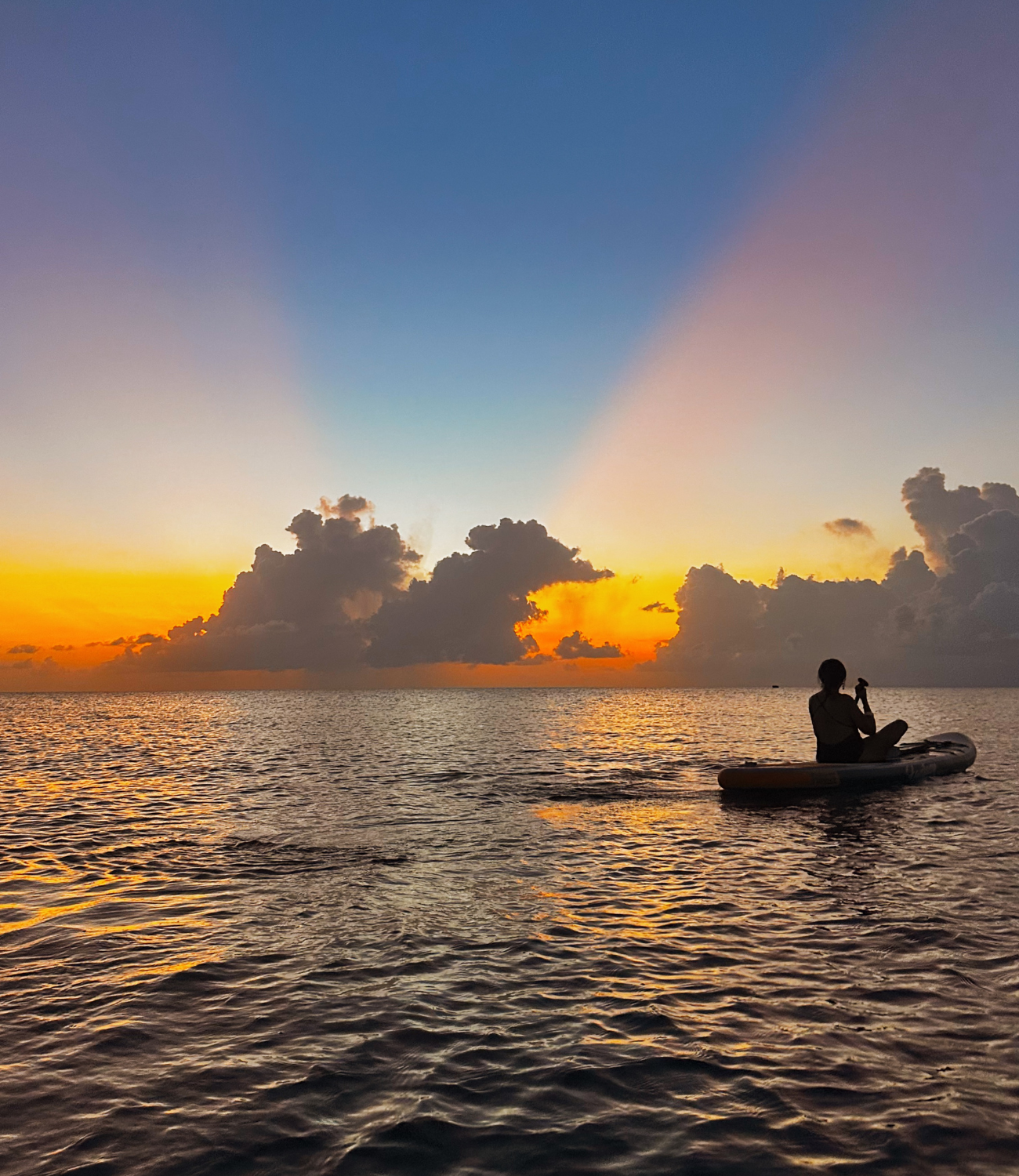 Atardecer con rayos de luz azul, amarillo y naranja, sobre el mar en las playas de san andres.