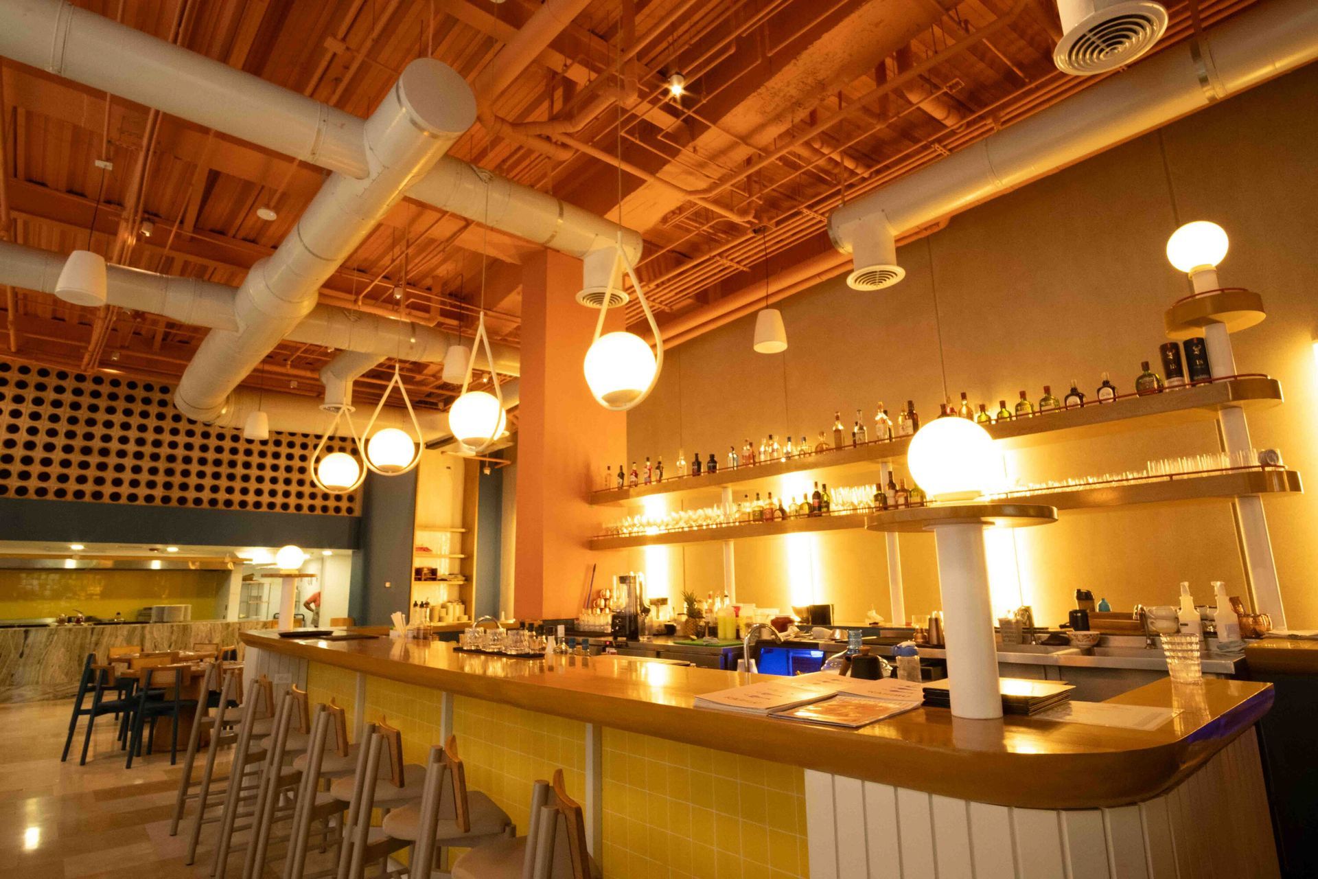 restaurantes en san andres islas, con mesas en madera, menú servido, iluminación cálida y diseño tropical
