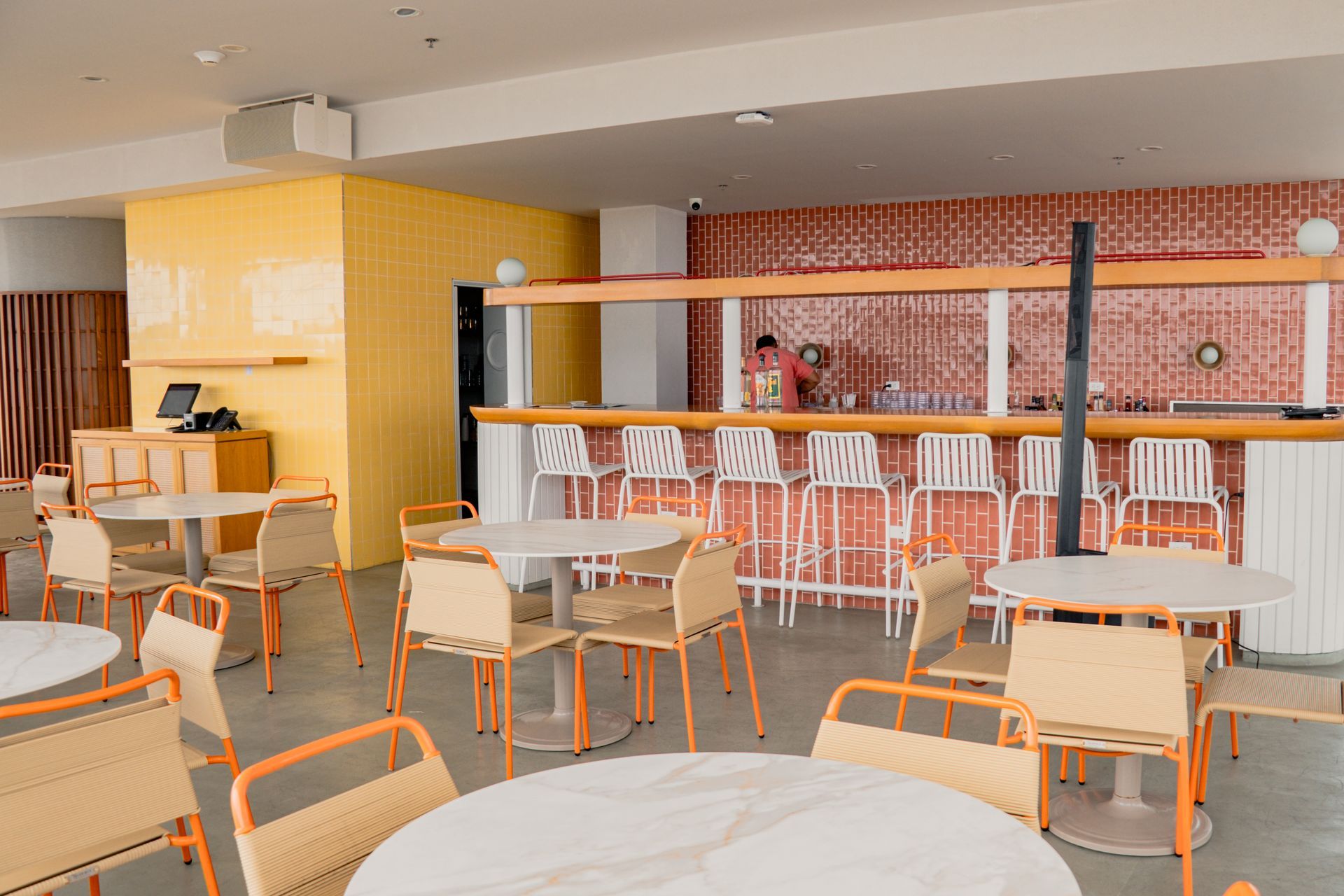 mejores restaurantes san andres en Zapadilly, con mesa central larga de madera, sillas coral y azules, y cocina abierta.