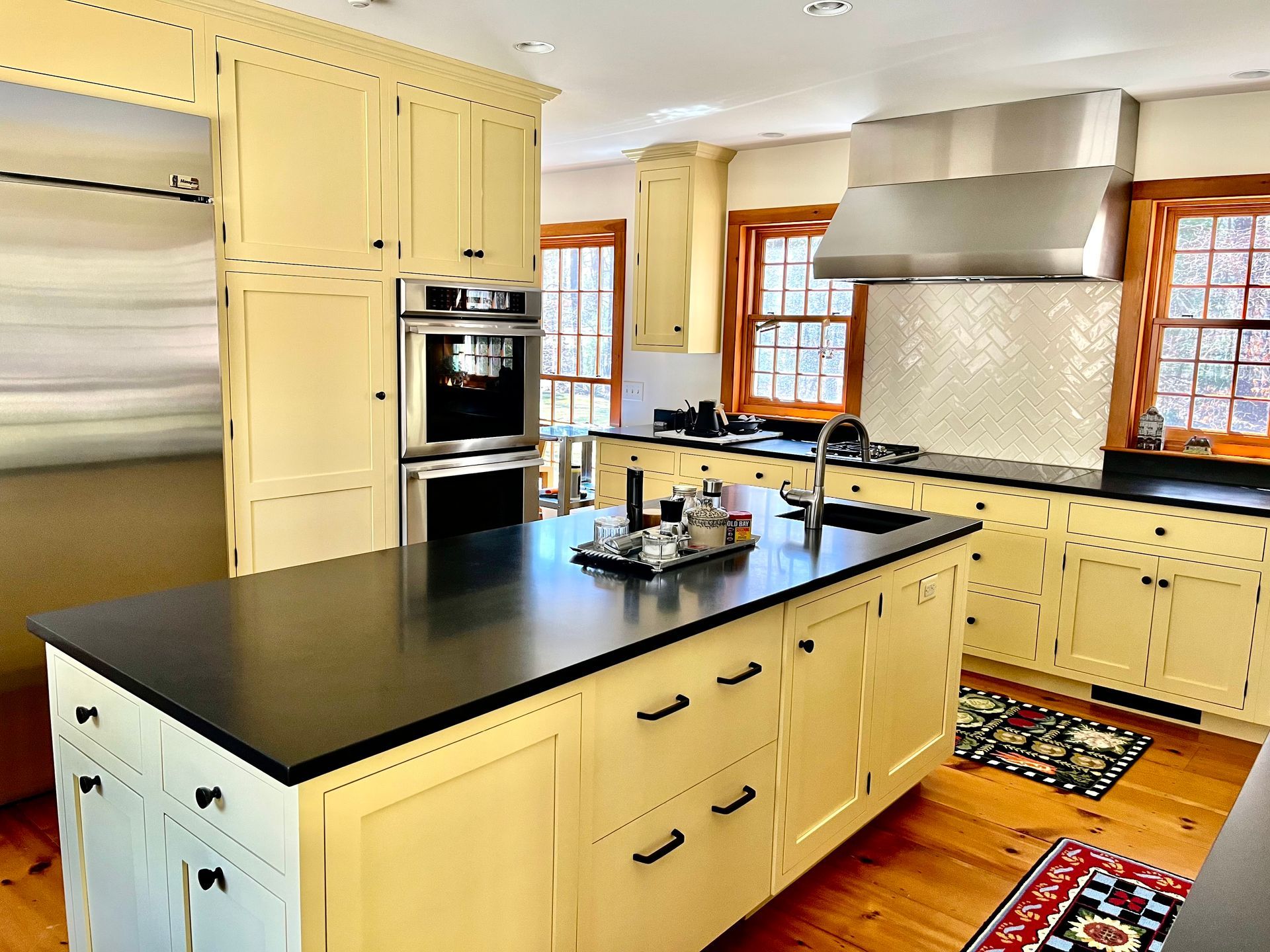 Modern kitchen with cream cabinets, black island countertop, and stainless steel appliances