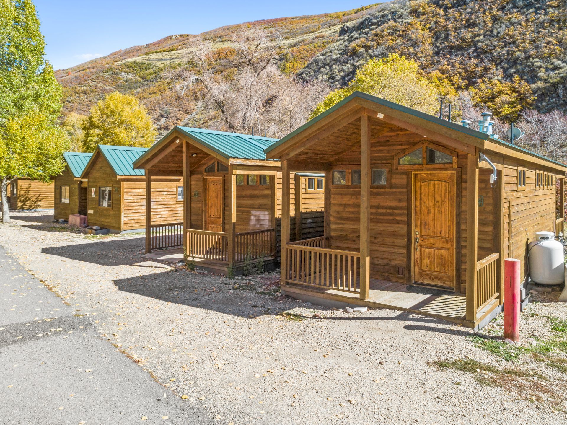 A row of wooden cabins sitting next to each other on a dirt road.