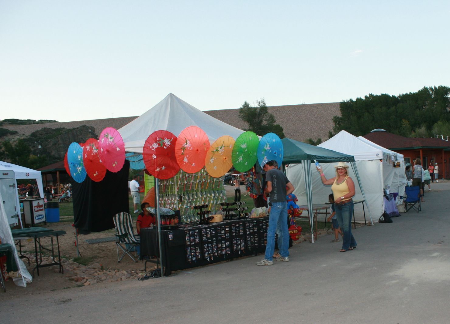 A group of people standing in front of a tent with balloons hanging from it