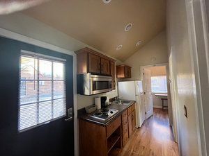 A kitchen with a refrigerator , microwave , stove and sink.
