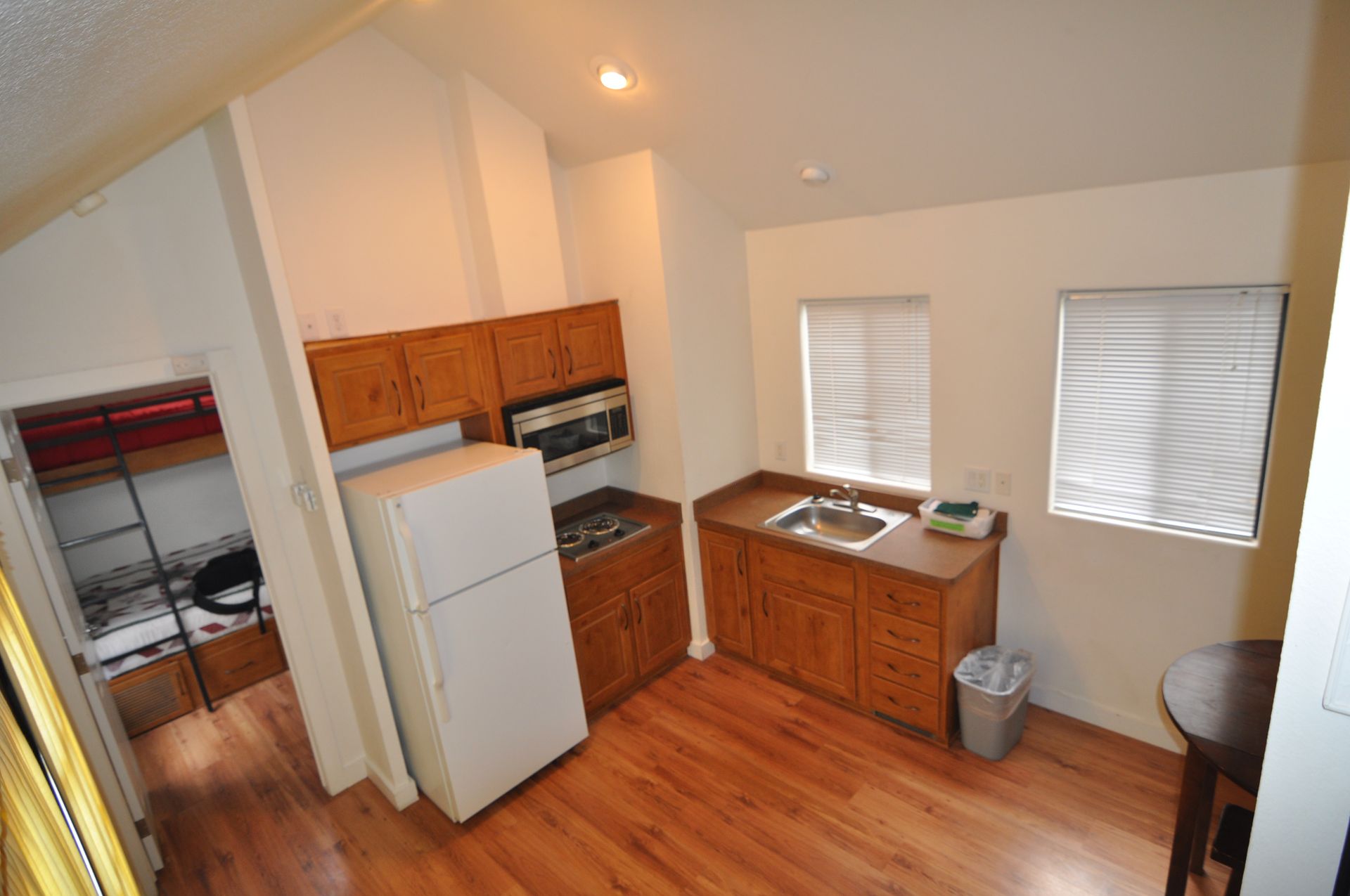 A small kitchen with a refrigerator , sink , stove and microwave.