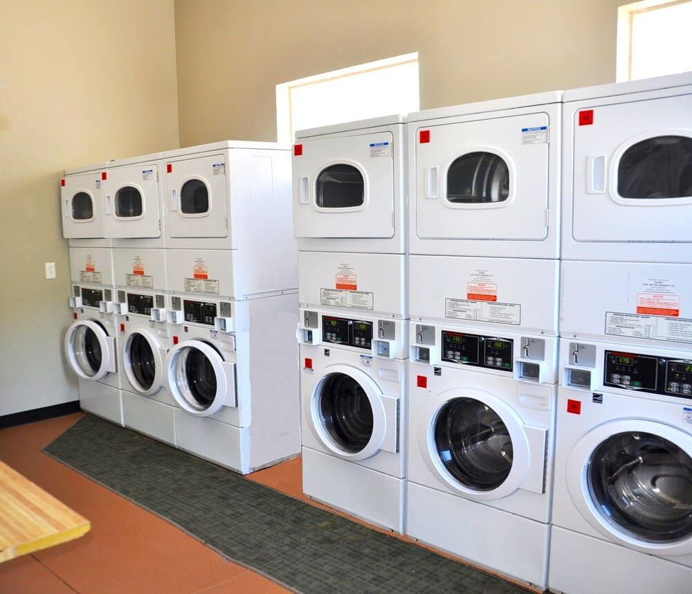 A row of washers and dryers in a laundromat