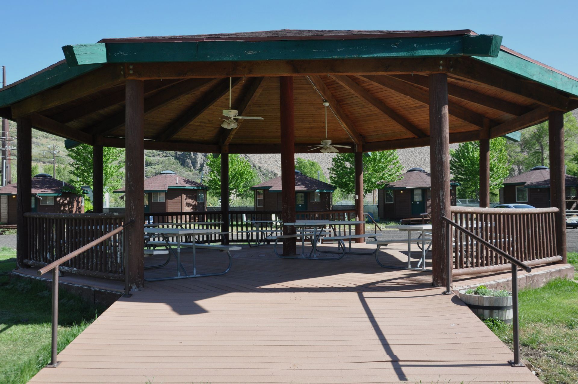 A wooden gazebo with picnic tables underneath it