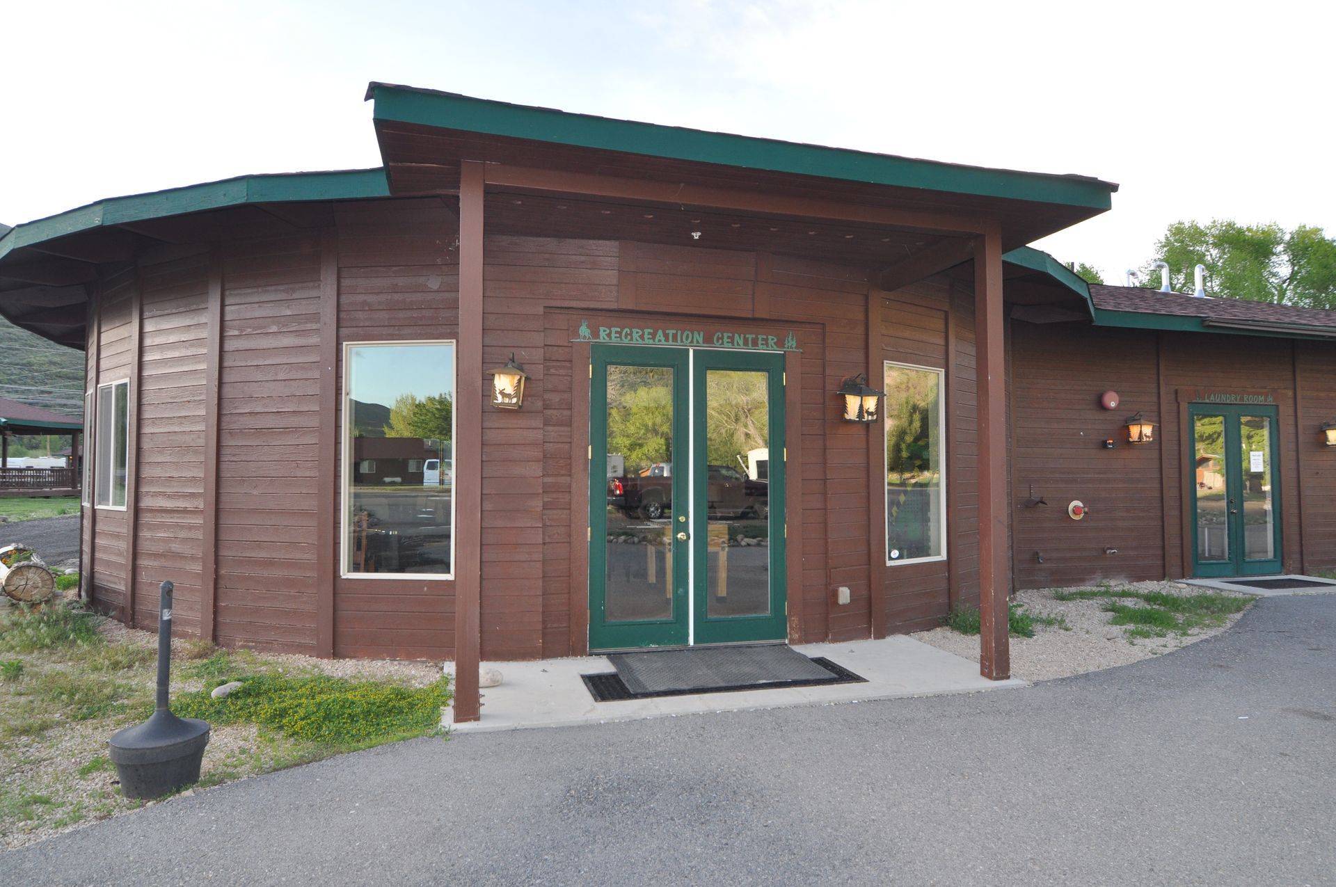 A large wooden building with green doors and windows