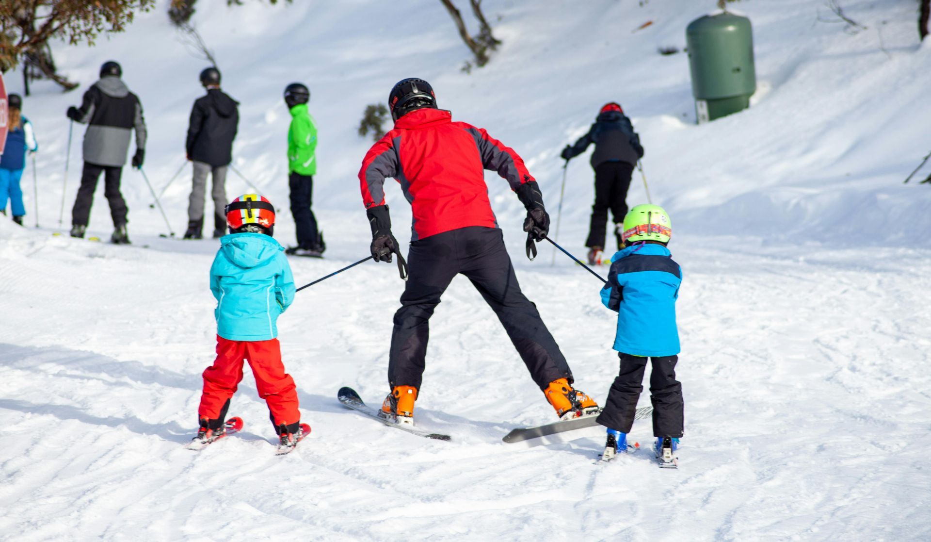 A group of people are skiing down a snow covered slope.