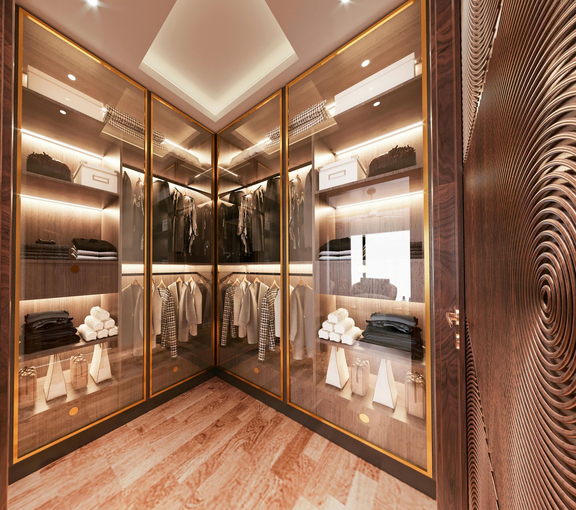 A modern walk-in closet featuring floor-to-ceiling glass cabinets with warm interior lighting and gold-toned frames.