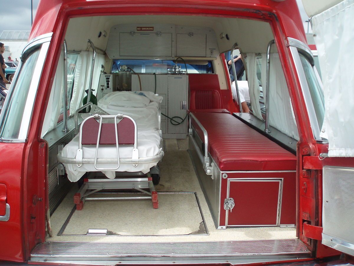 A red ambulance with a stretcher in the back