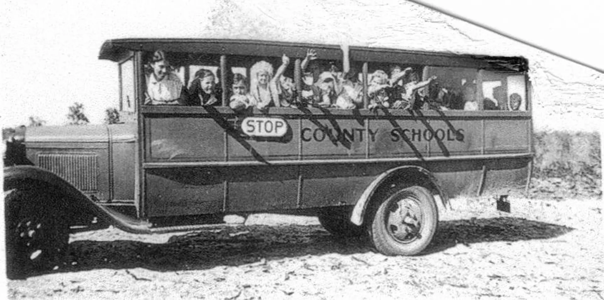 A black and white photo of a county school bus