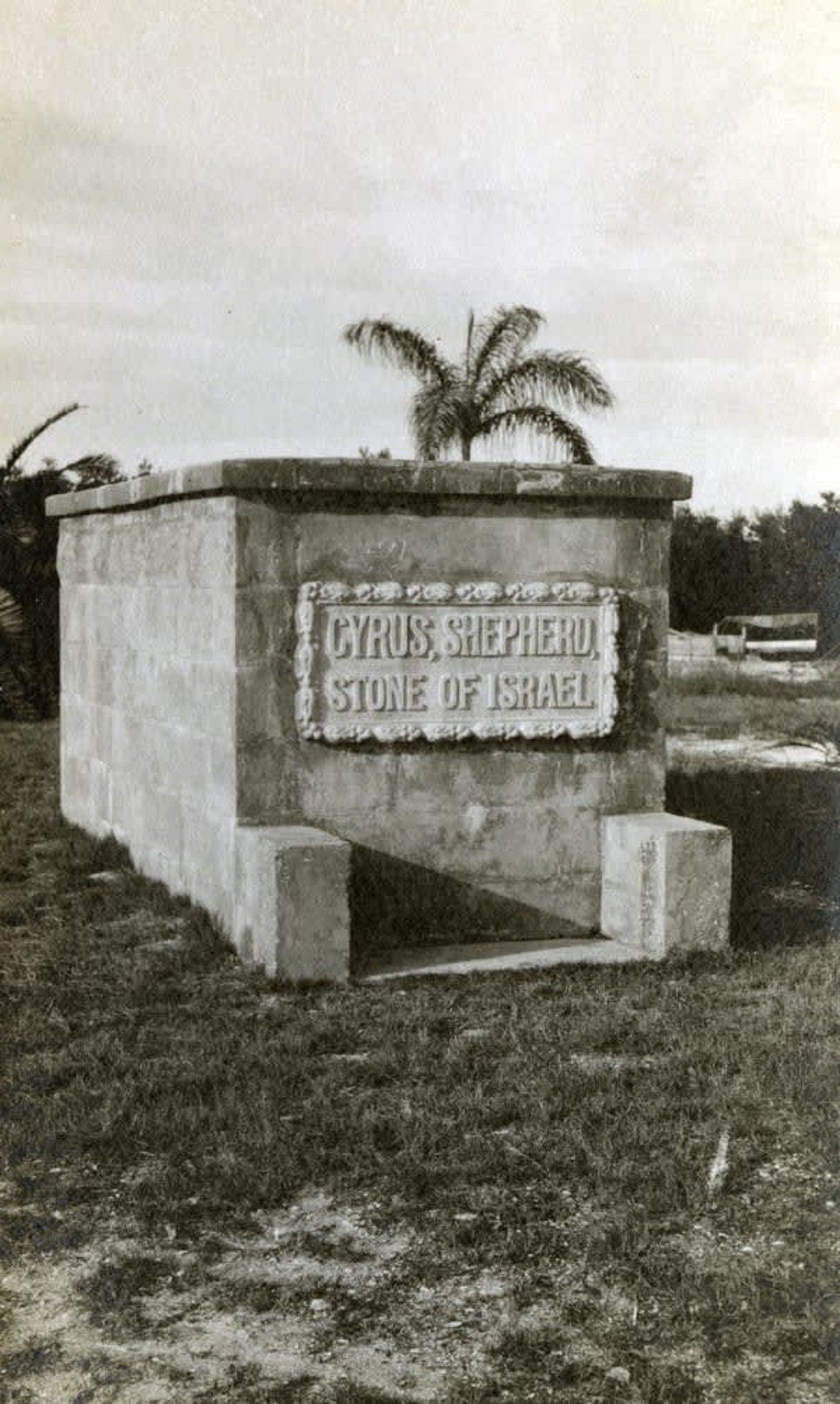 A black and white photo of a monument in the middle of a field.