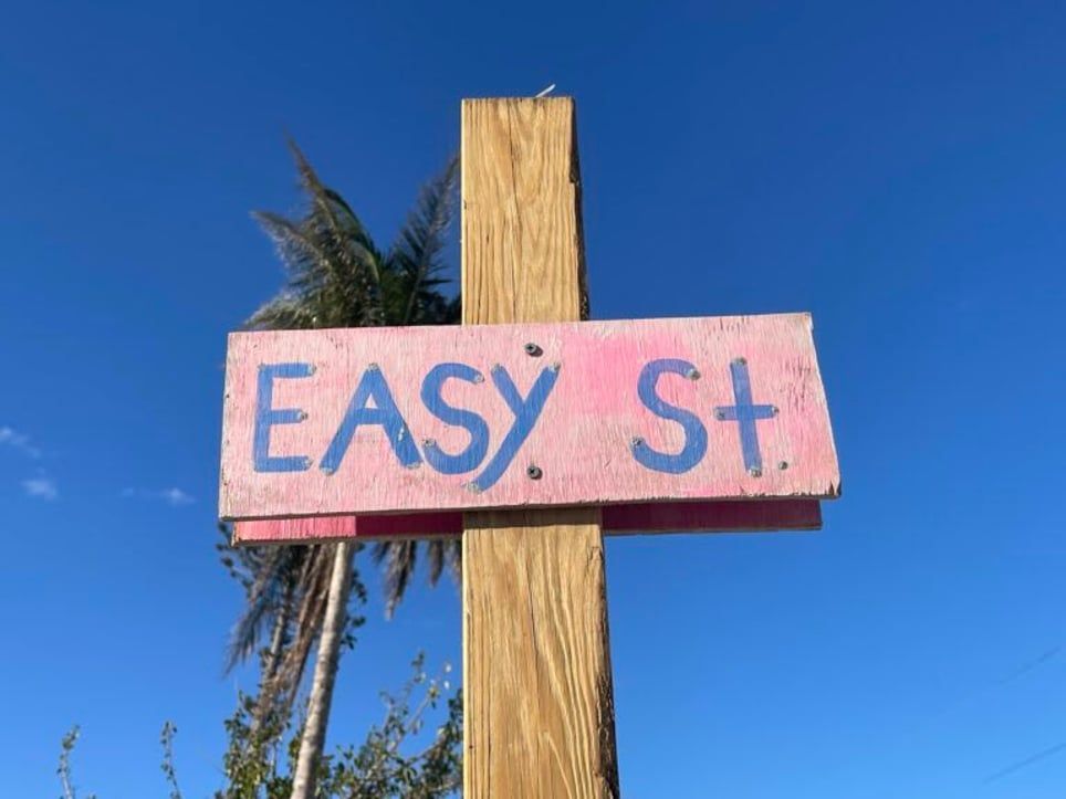 A pink and blue sign that says easy st.